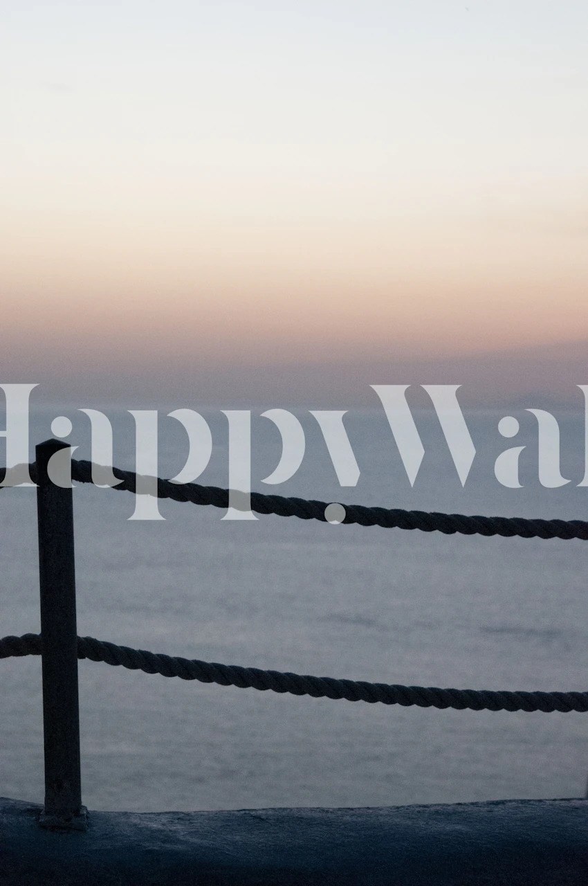 Zonsondergangsilhouet op Santorini met een touwomheining en een muurschildering met kalme zee