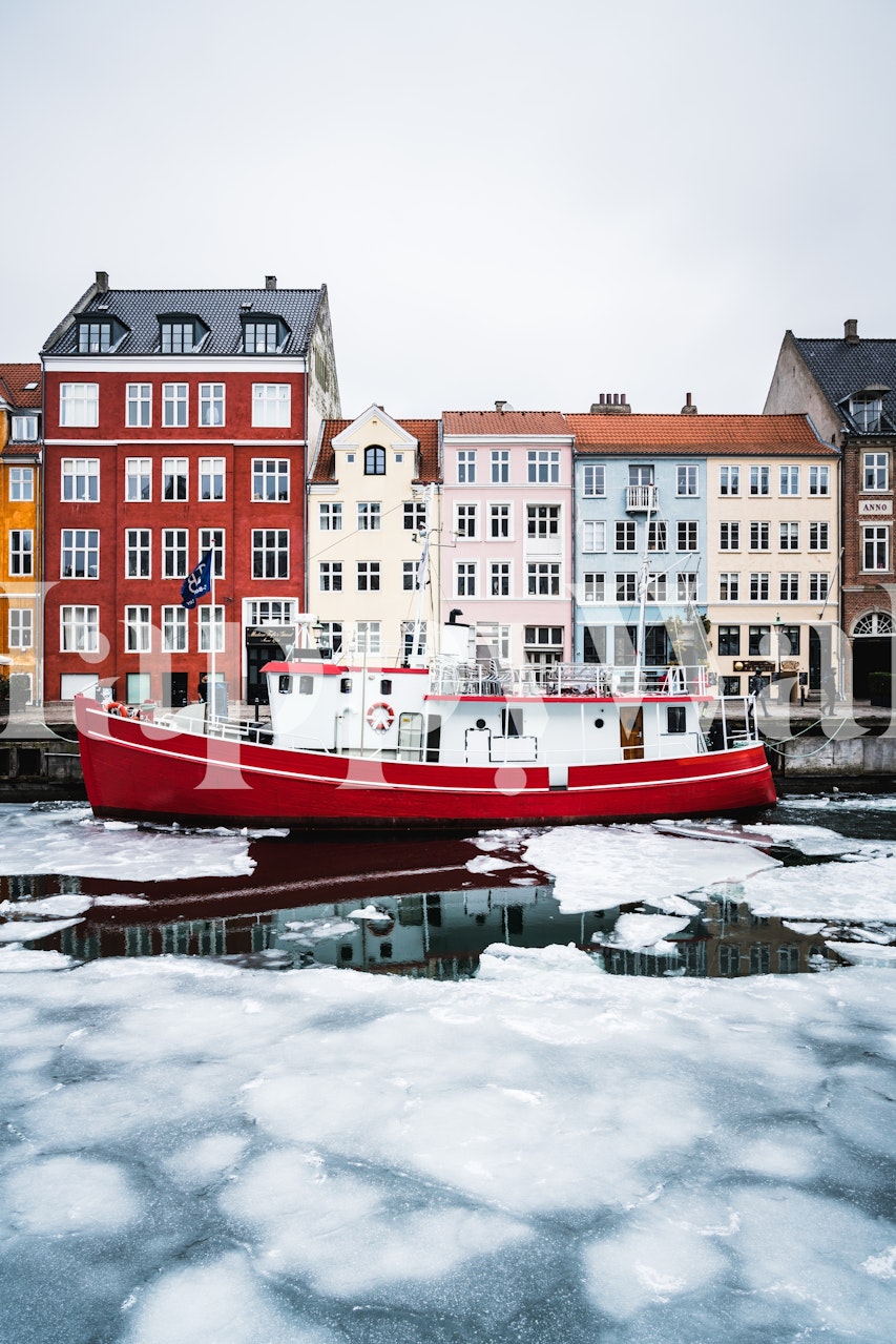 Colorful buildings and a red boat in icy waters wallpaper