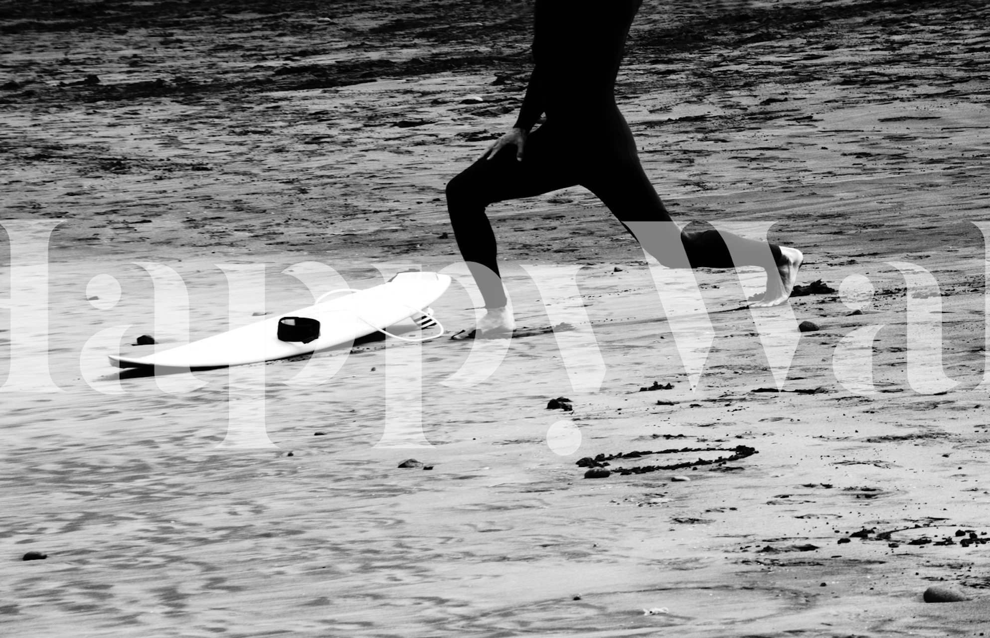 A black and white wall mural depicting the dynamic silhouette of a surfer with their board on the beach.