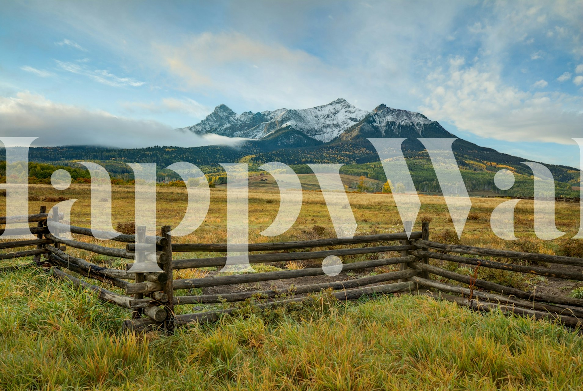 Mountain landscape with green fields and snowy peaks wallpaper