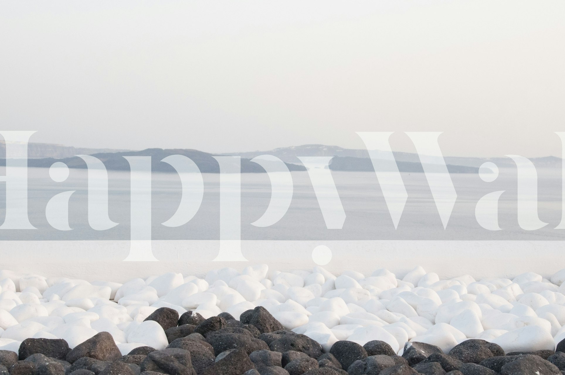 Santorini-inspired wall mural with pebbles and hazy island horizon