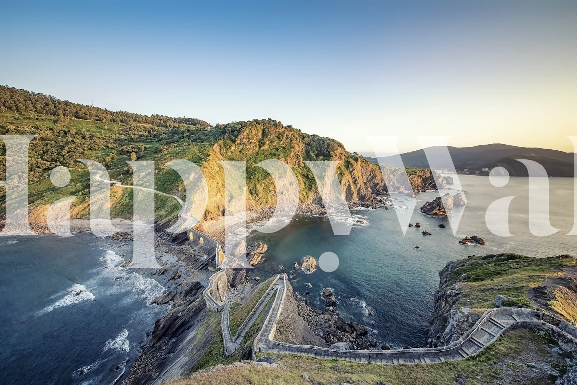 Coastal landscape featuring green hills and blue sea wallpaper