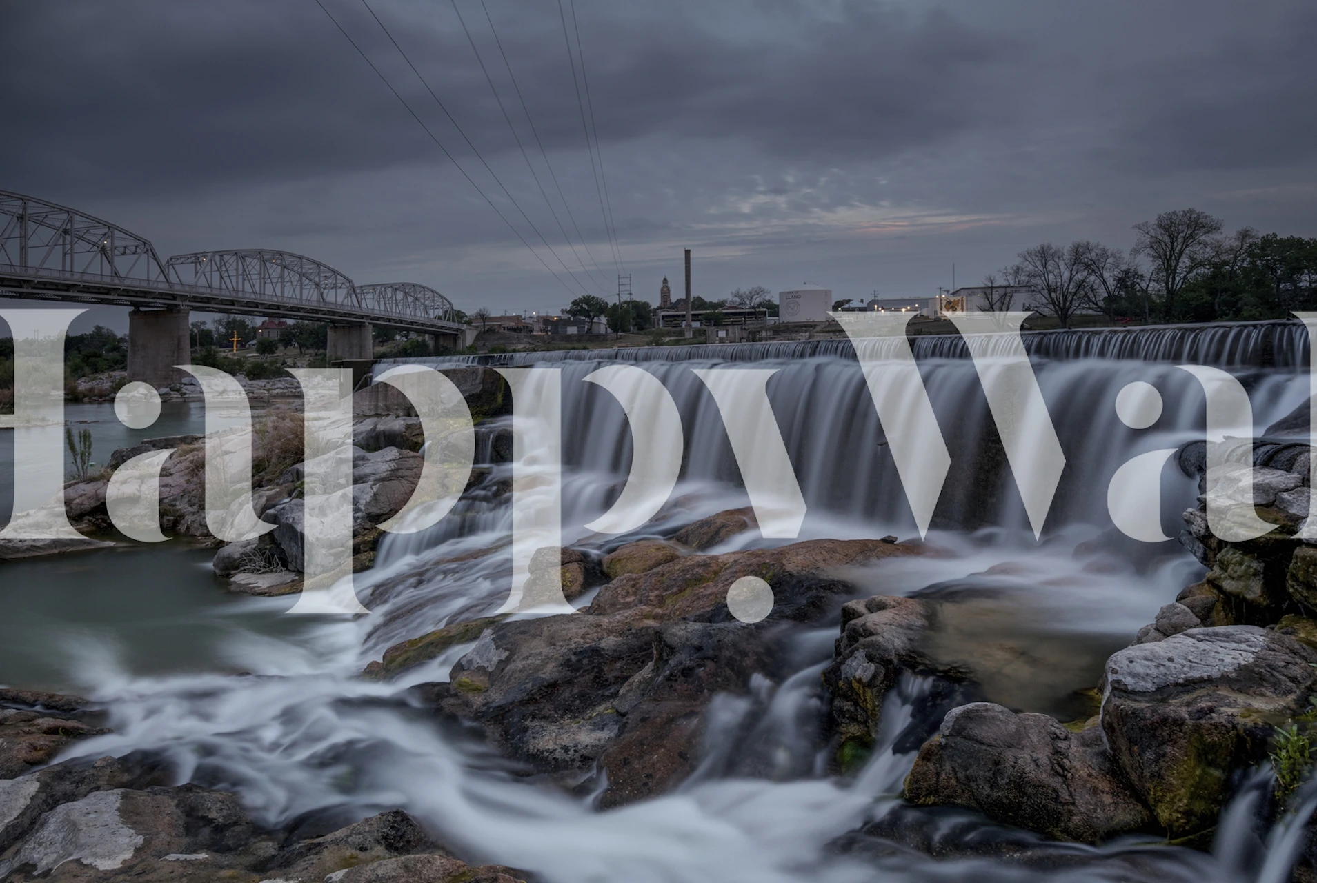 Llano Spillway Texas wall mural featuring a waterfall with rocks and cloudy skies