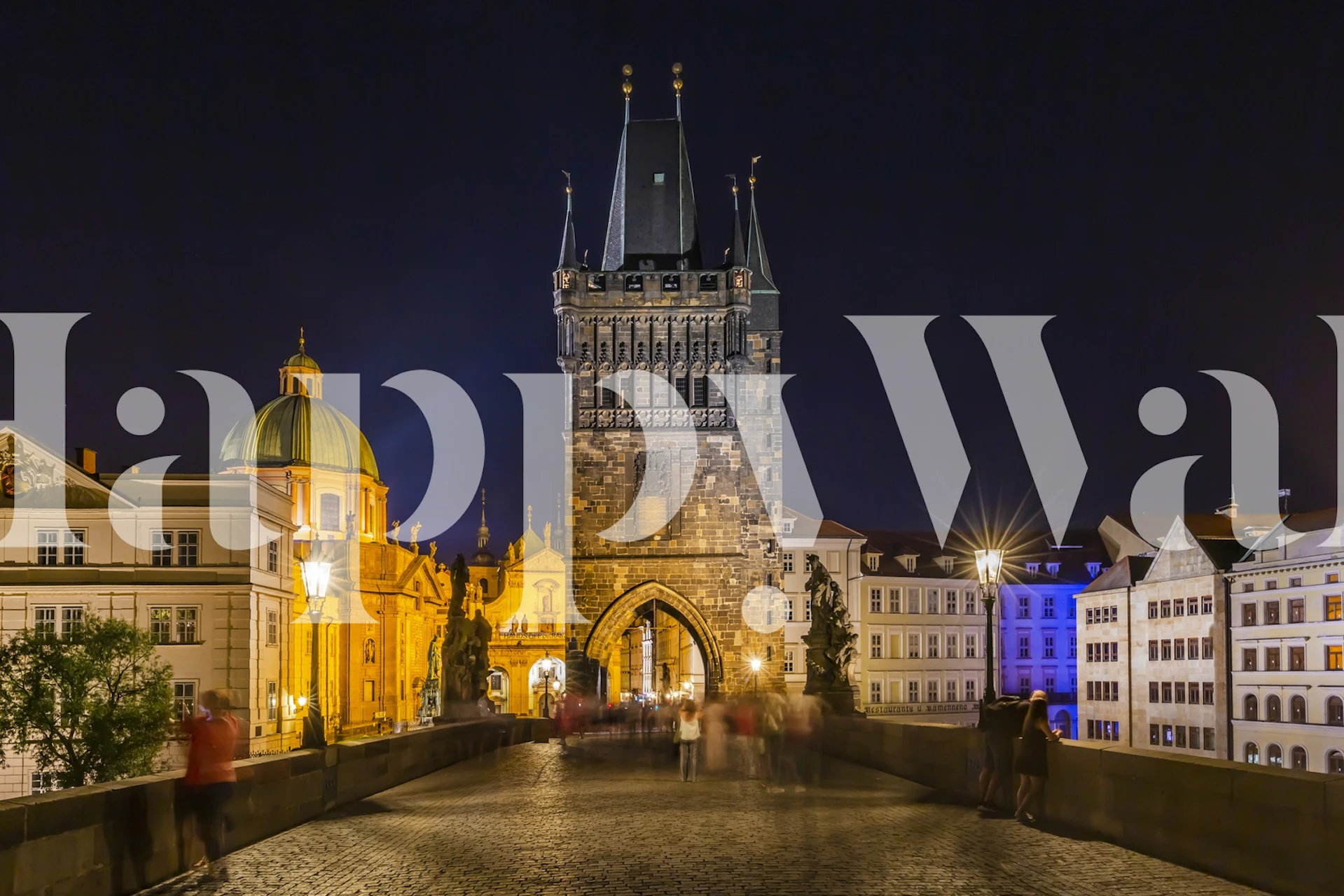 Nighttime scene of Charles Bridge with illuminated buildings and city lights wallpaper