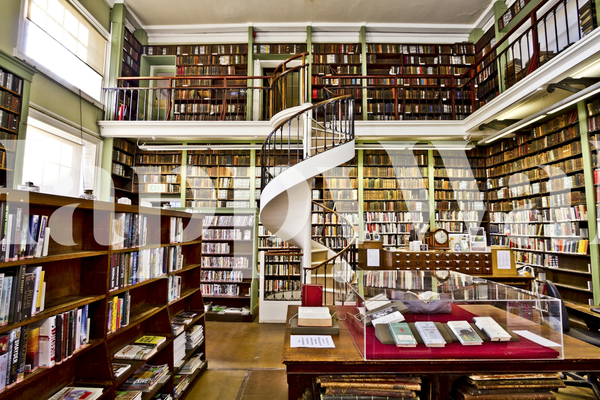 Library interior with spiral staircase and wooden bookshelves wallpaper