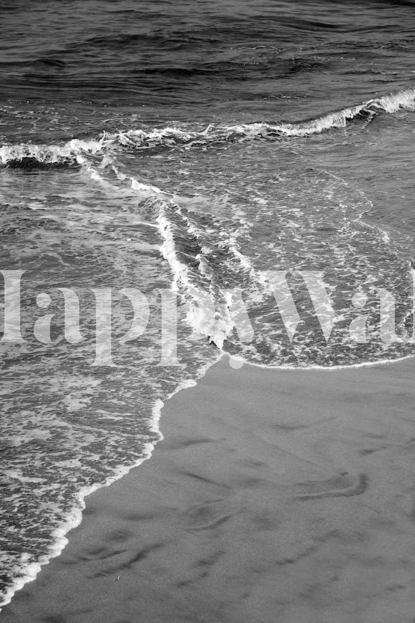 Ocean waves on sandy shore in black and white wallpaper