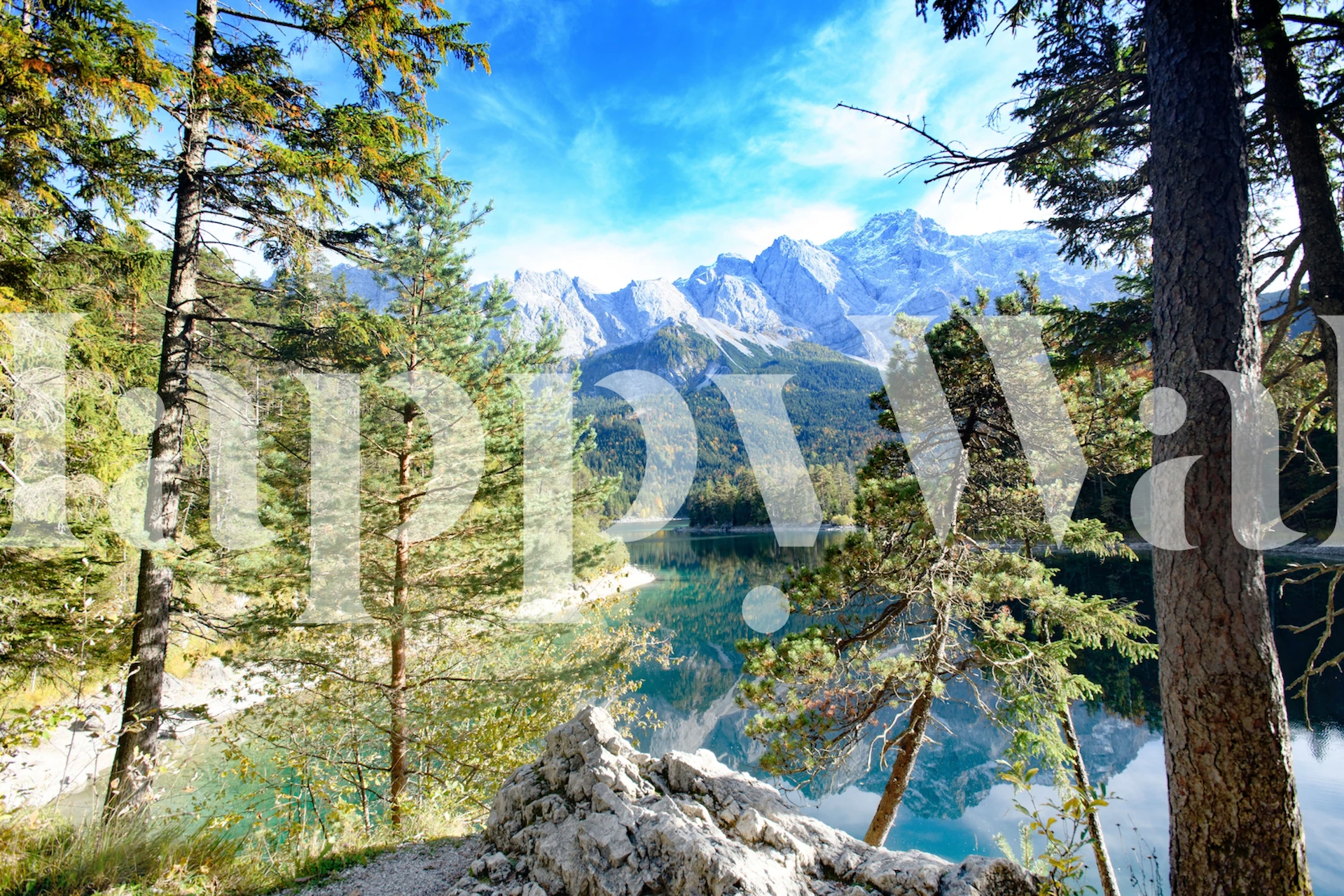 Mountain lake scene with blue water, green trees, and mountains wallpaper