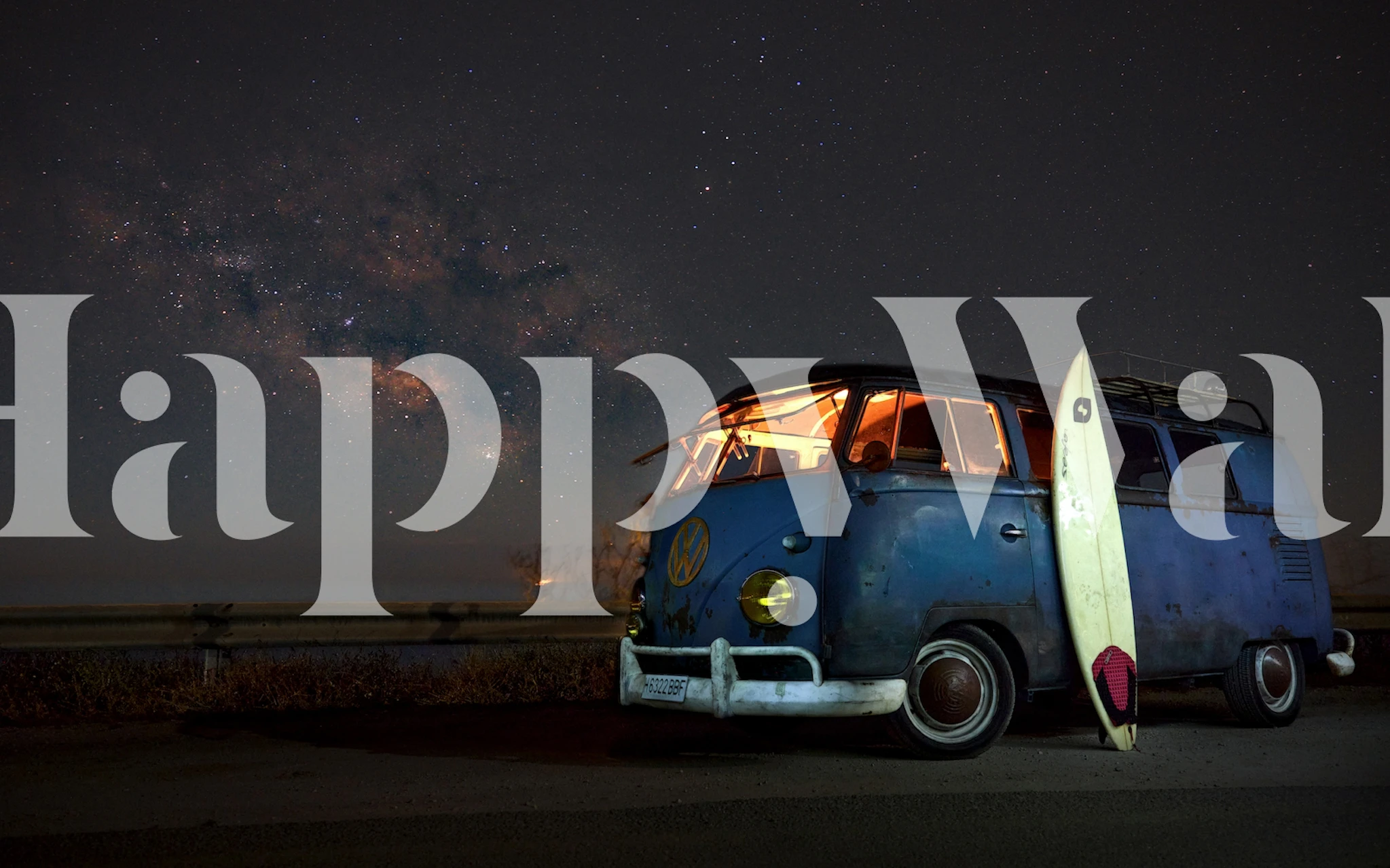 Vintage camper van under night sky with surfboard wall mural