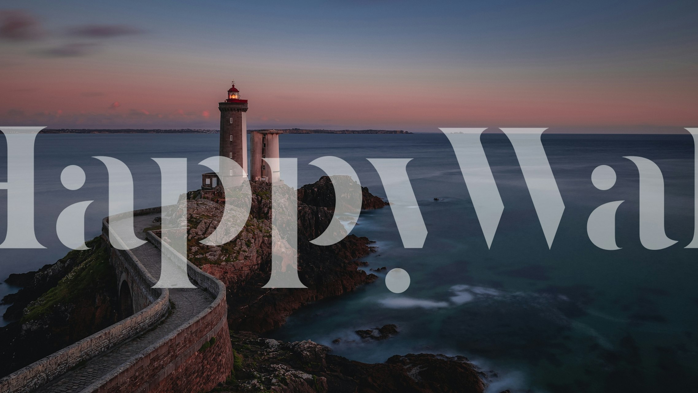 Lighthouse on rocky shore at sunset with ocean waves wallpaper