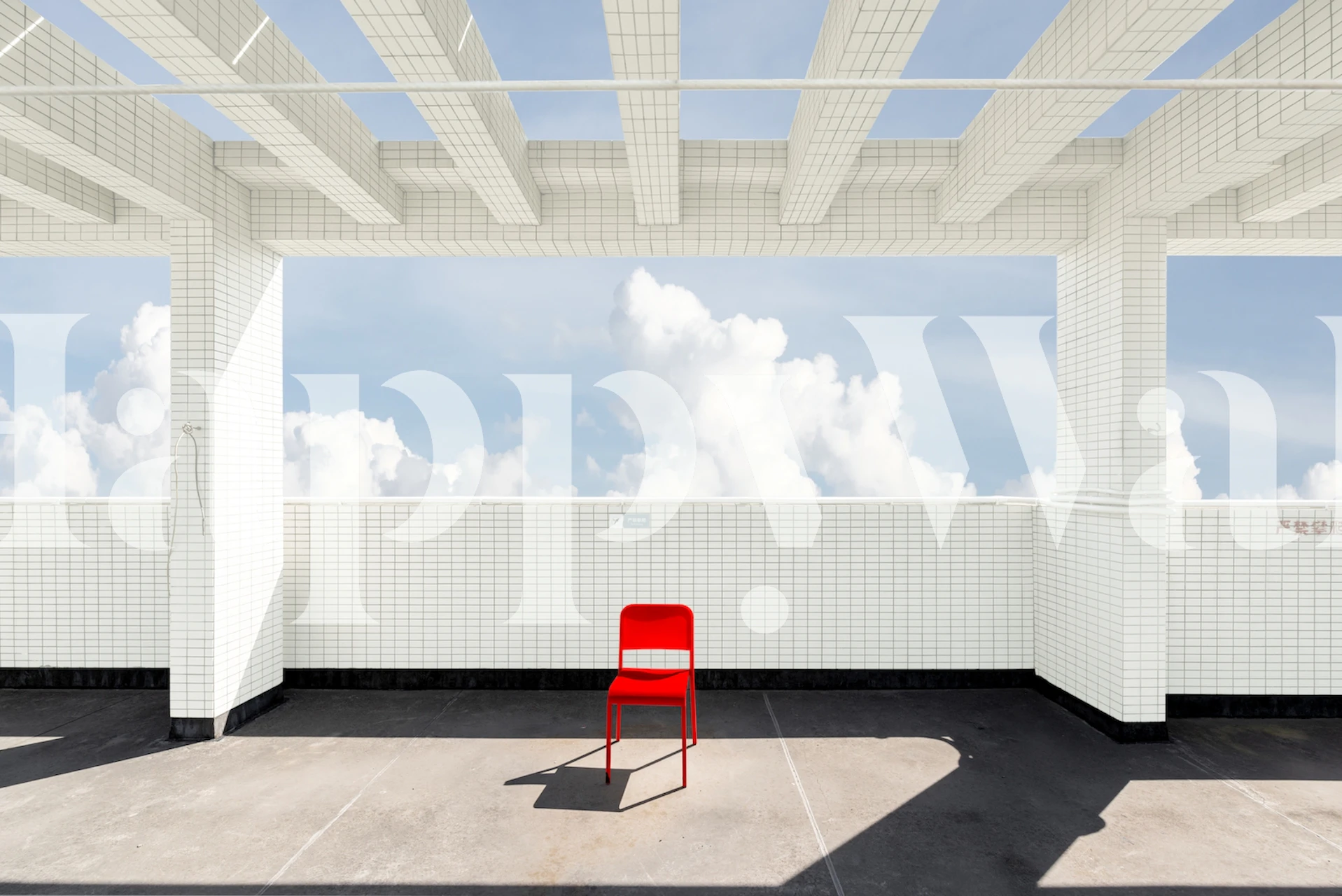 White brick wall with a bright red chair under a blue sky wallpaper