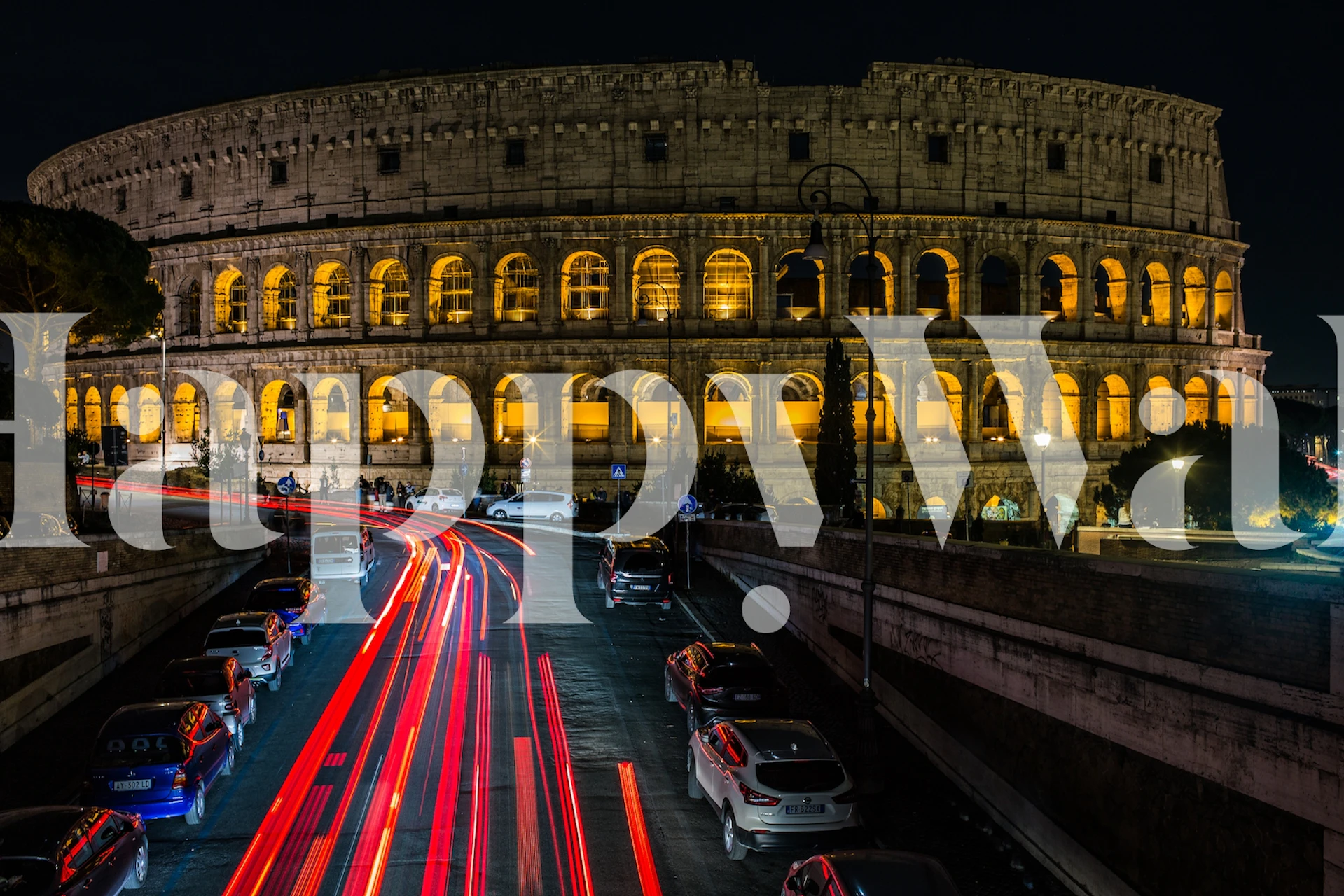 Colosseum at night wall mural with illuminated arches and traffic streaks