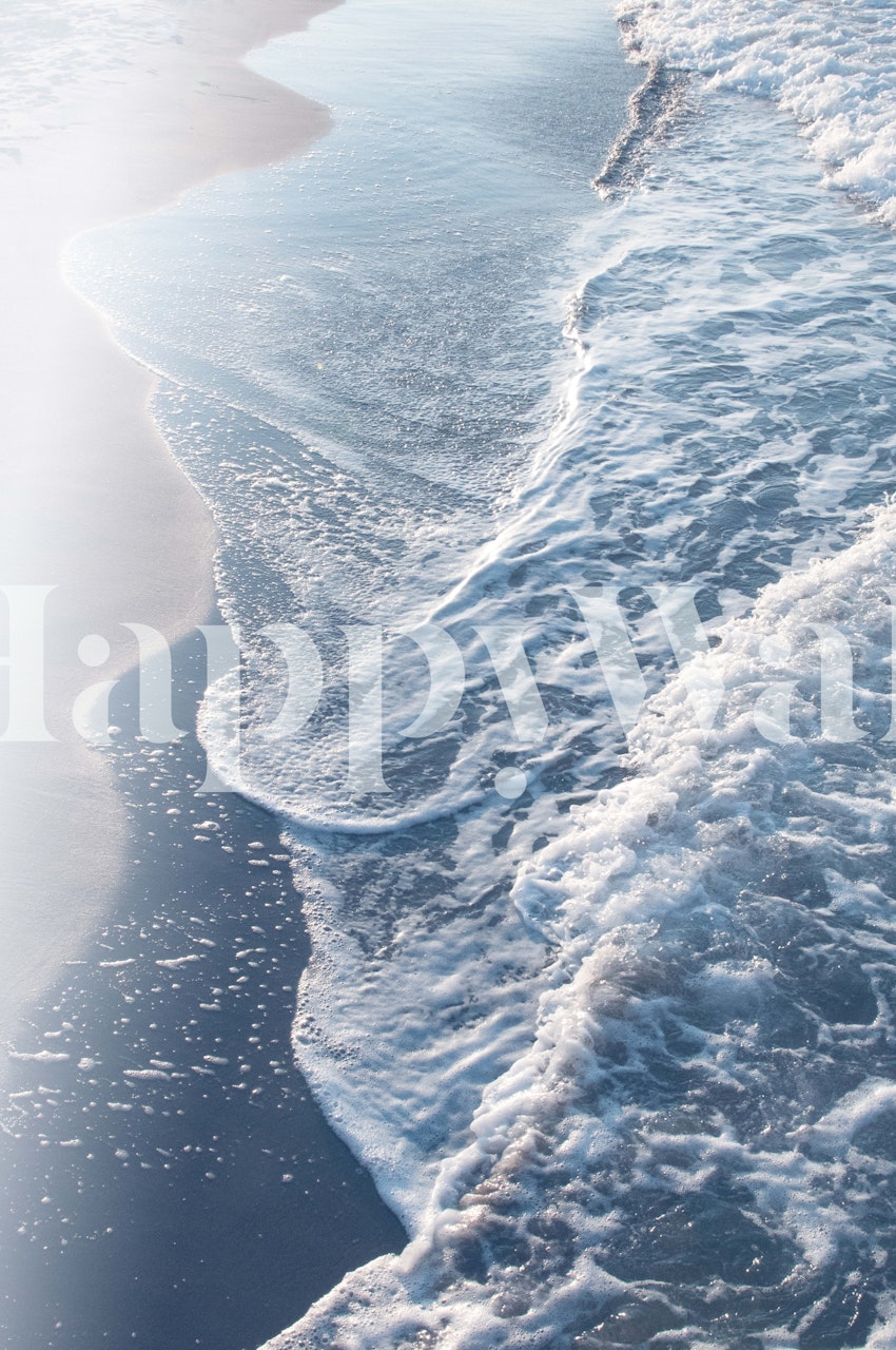 Ocean waves crashing on a sandy shore in blue wallpaper