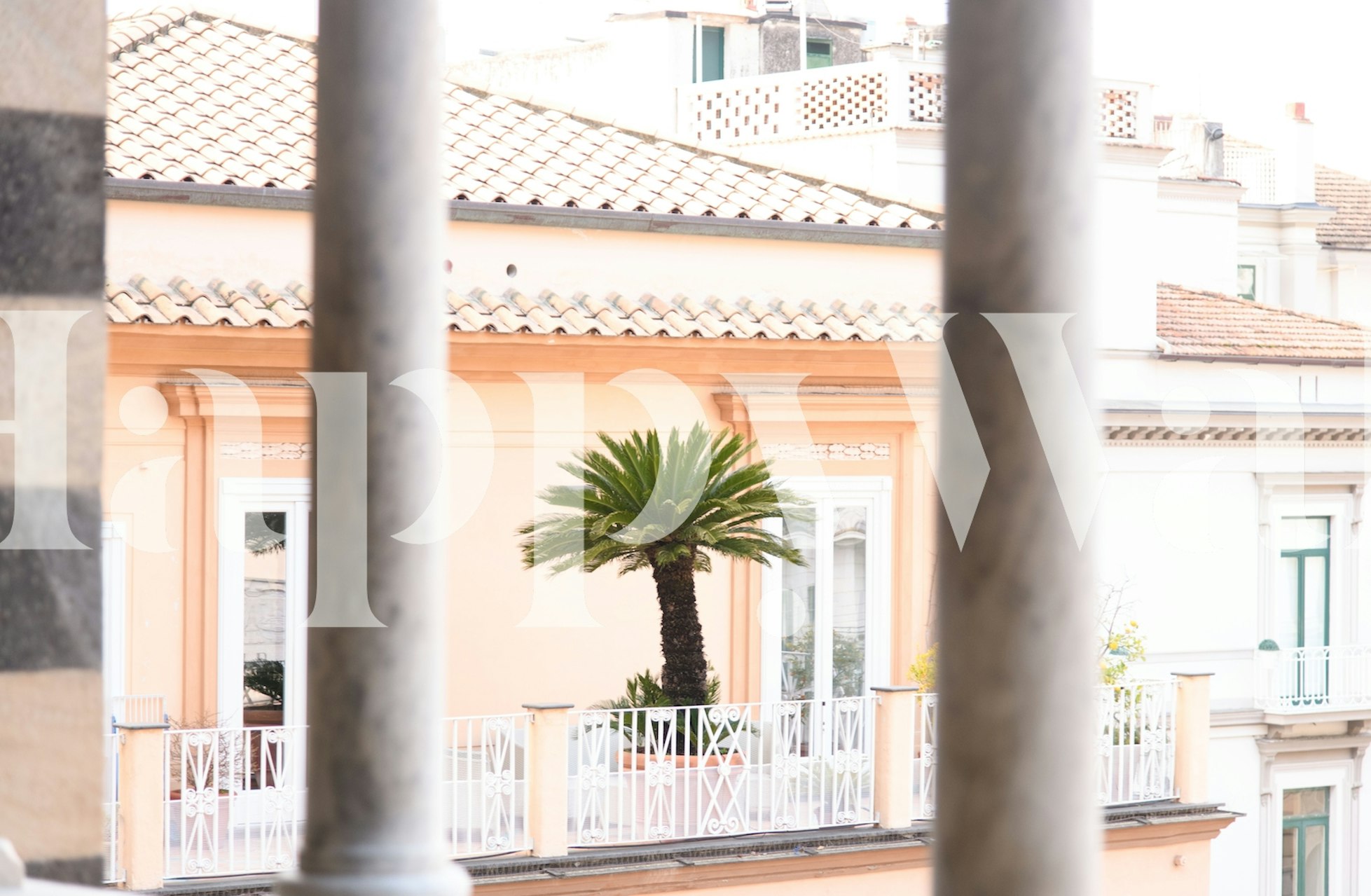 Amalfi Pastel Palm View 1 papel de parede em um quarto