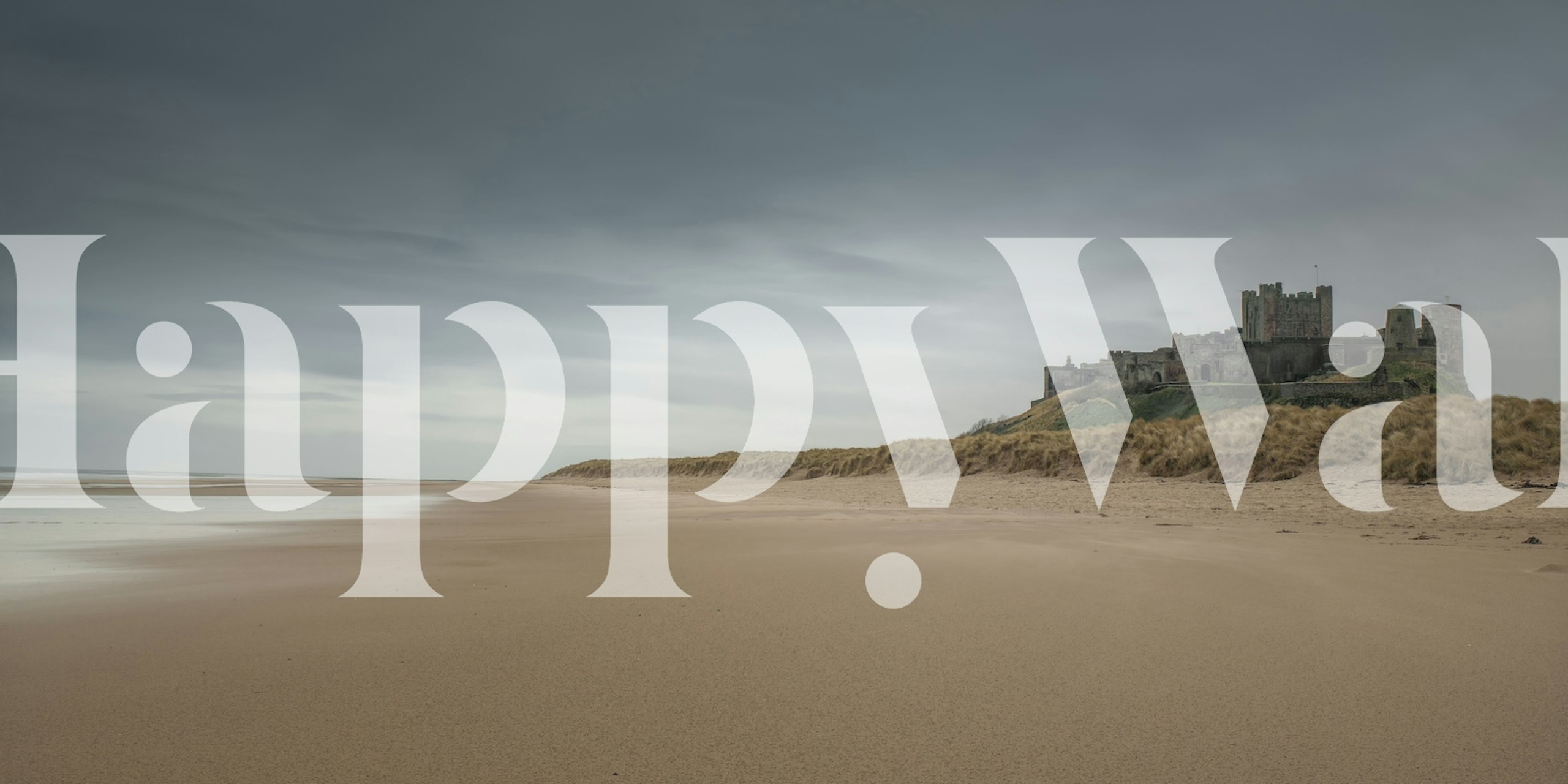 Bamburgh Castle on sandy beach with cloudy sky wallpaper