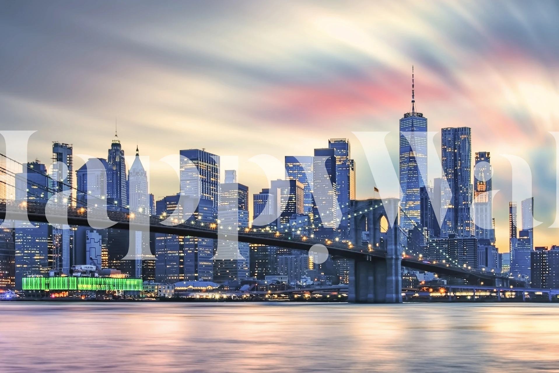 Skyline van New York City in de schemering met warme verlichting op de gebouwen en de Brooklyn Bridge op de voorgrond