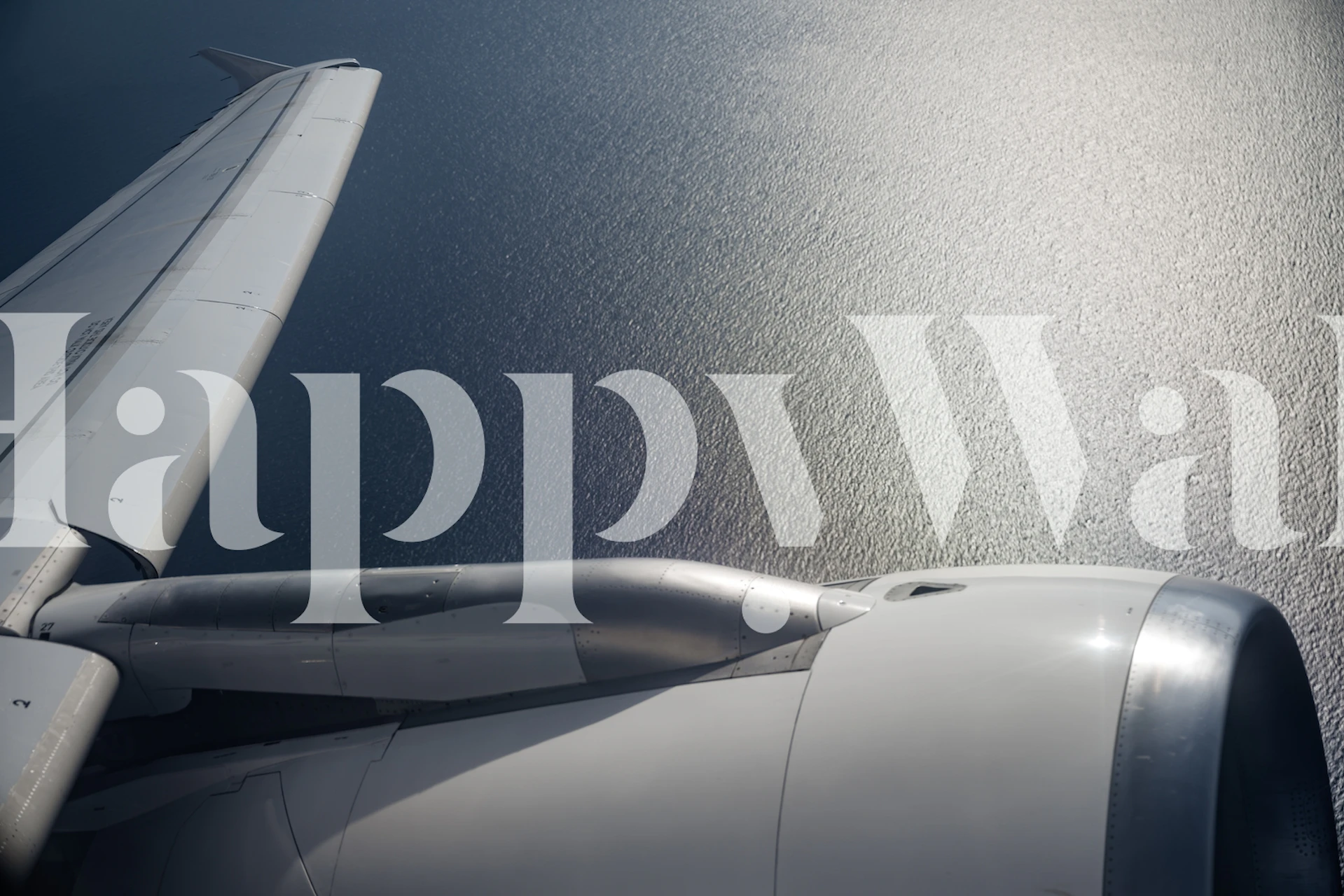 Airplane wing above ocean water reflecting sunlight wallpaper