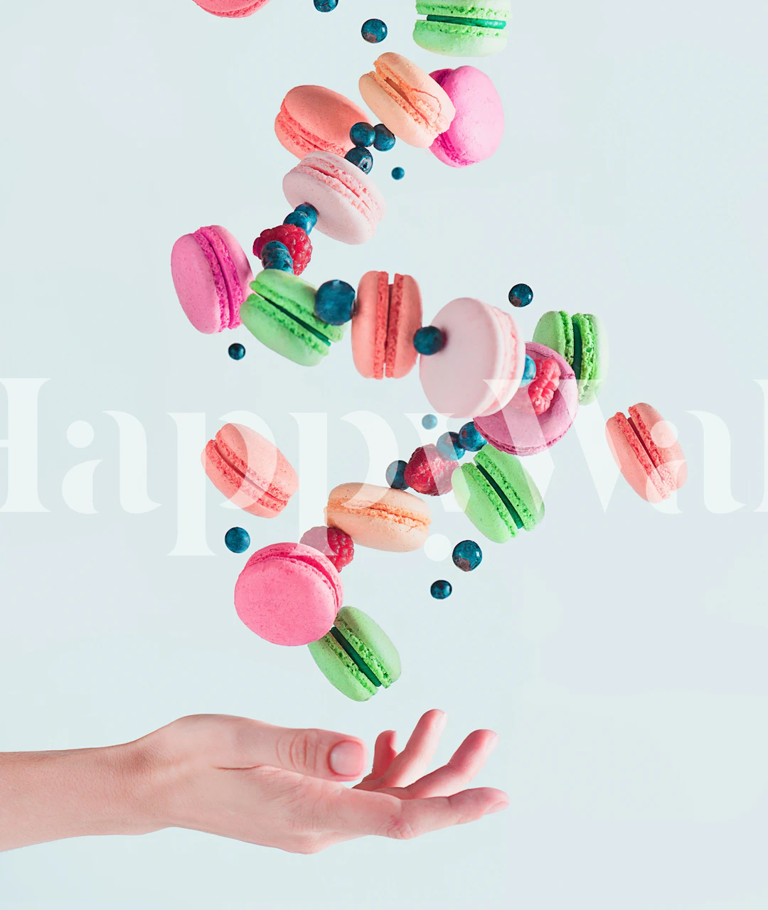 Colorful macarons in pink, green, and blue on light background wallpaper