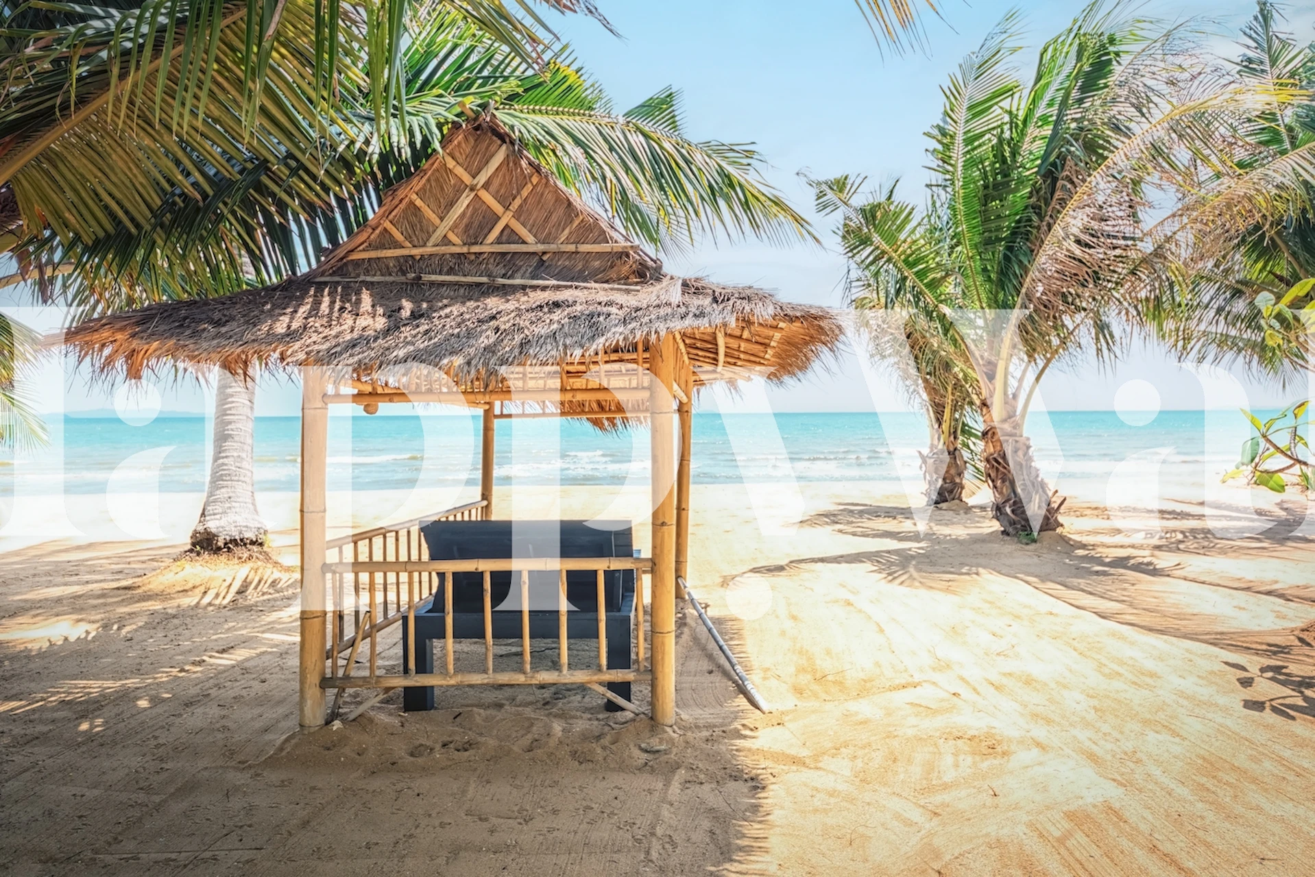Reetgedeckte Hütte an einem Sandstrand mit Palmen und Wandbild mit Meerblick