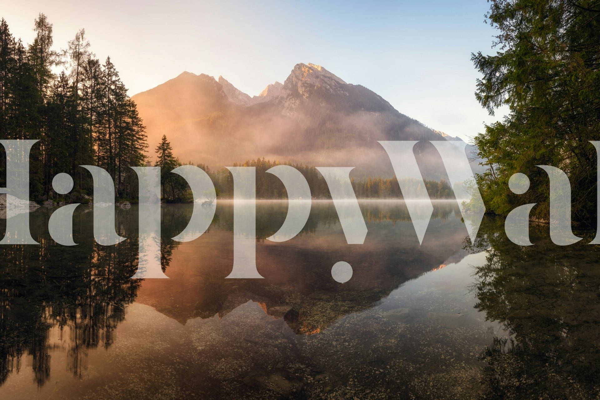 Mountain lake reflecting misty mountains and trees wallpaper