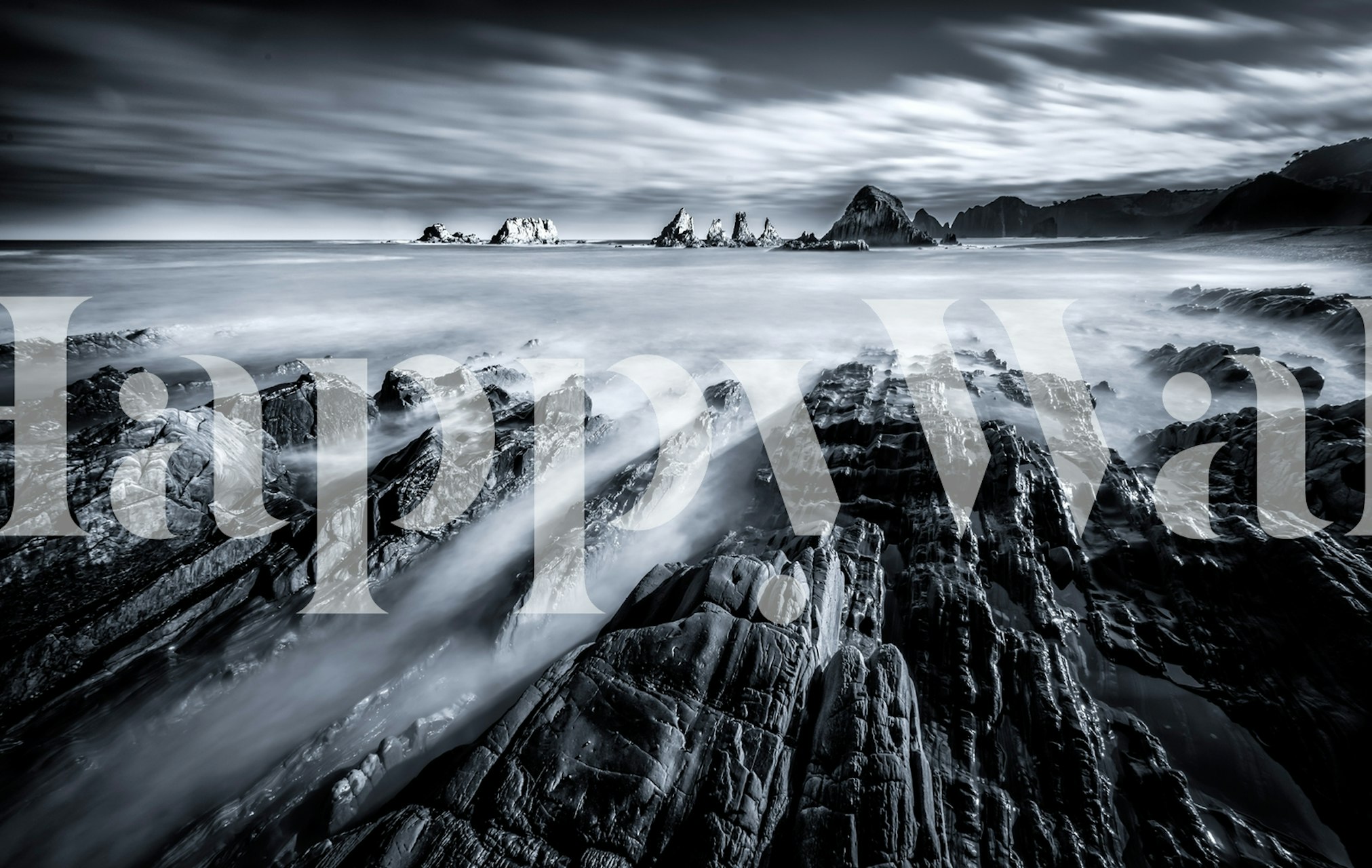 Black and white coastal landscape wallpaper depicting rocky shorelines and ocean waves.