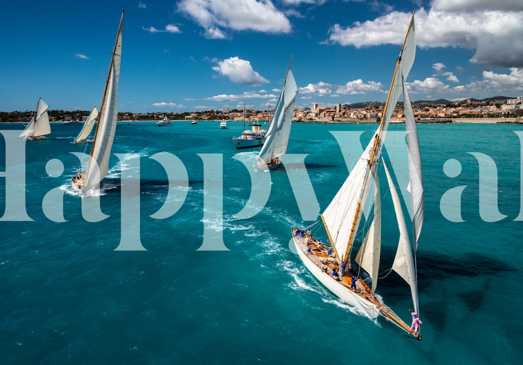Sailing boats on blue ocean water under bright clouds wallpaper