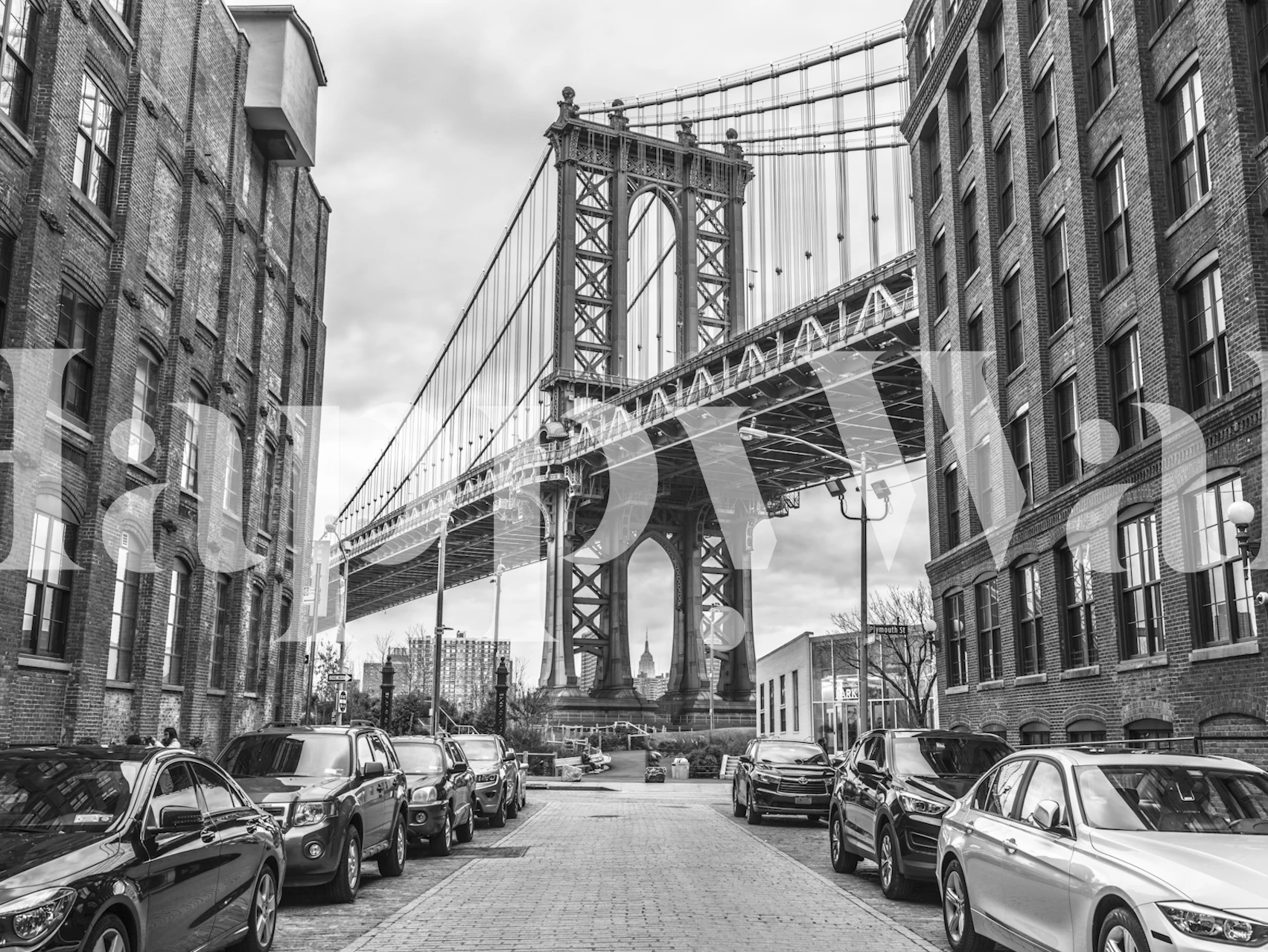 Black and white image of Manhattan Bridge with city buildings and cars wallpaper