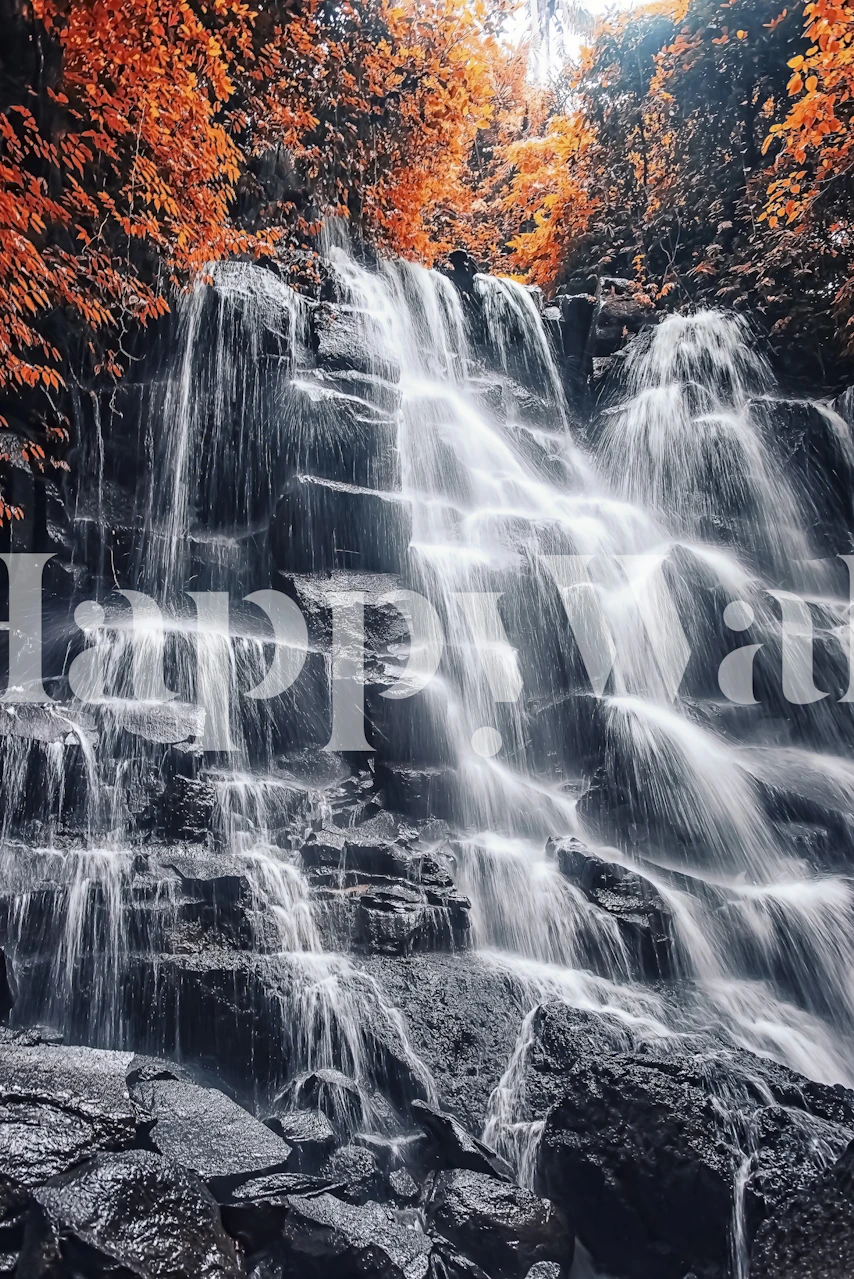 Waterfall flowing over rocks surrounded by orange leaves wallpaper