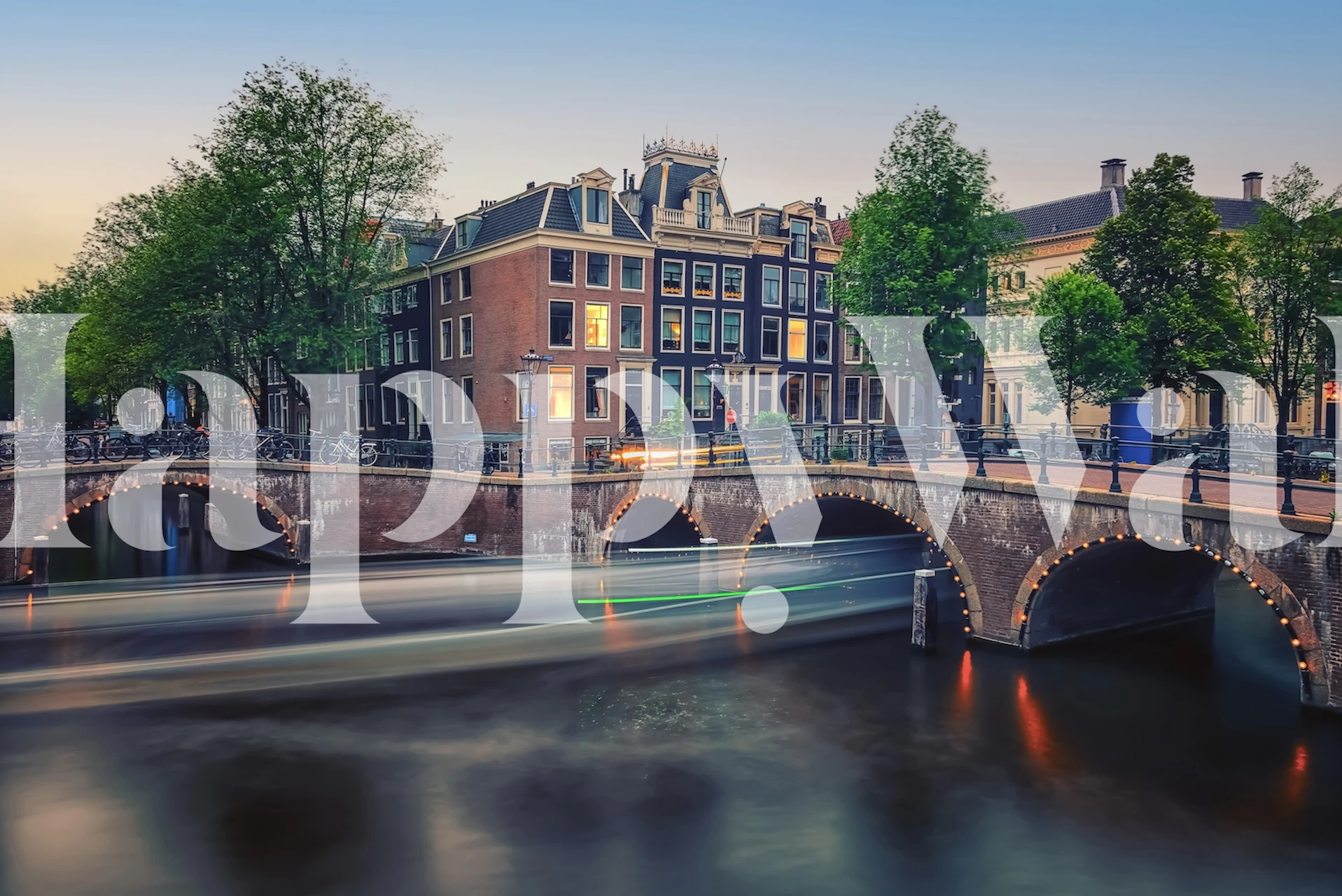 Amsterdam evening scene with a river, trees, and bridges wallpaper