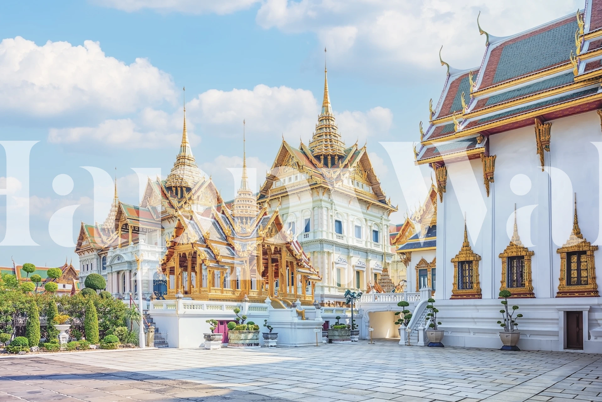 Carta da parati raffigurante un grande palazzo con guglie dorate e dettagli decorati sotto un cielo azzurro.