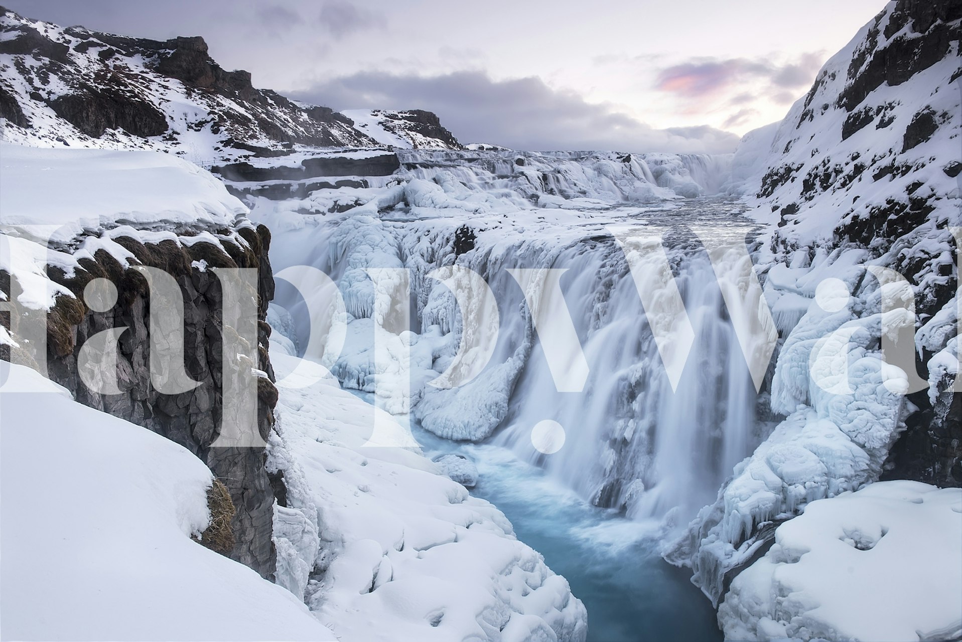 Fotomural cascada congelada con acantilados nevados y azules helados
