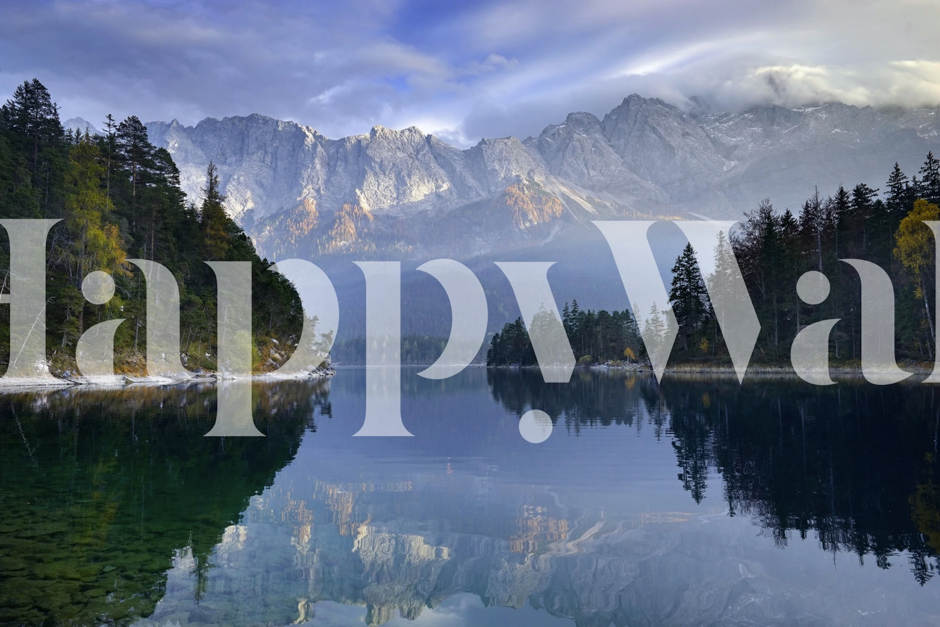 Mountain lake reflecting mountains and trees in blue and green wallpaper