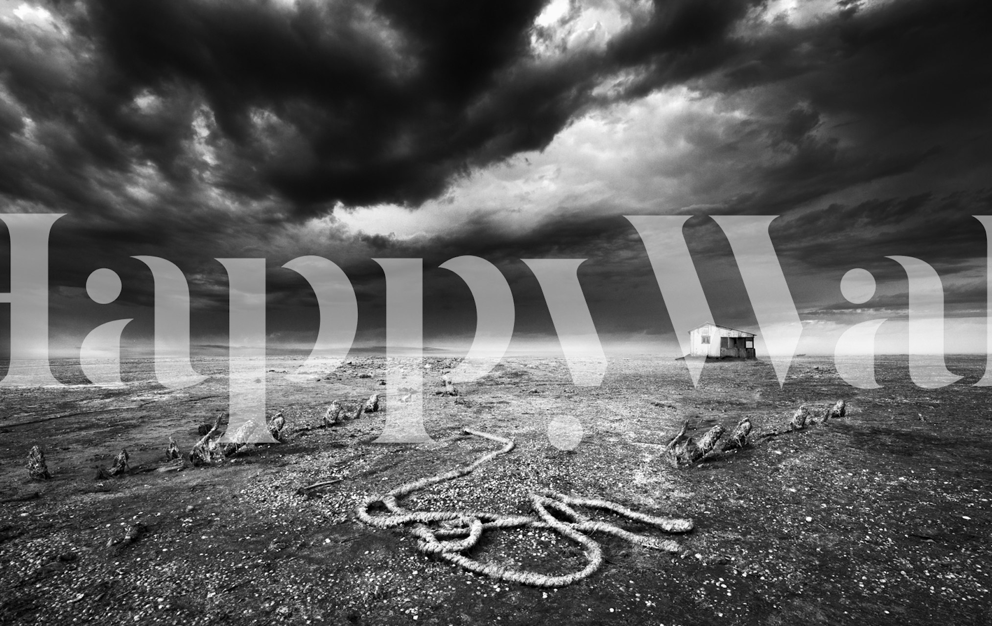 Black and white landscape wallpaper featuring an abandoned house and dark stormy sky