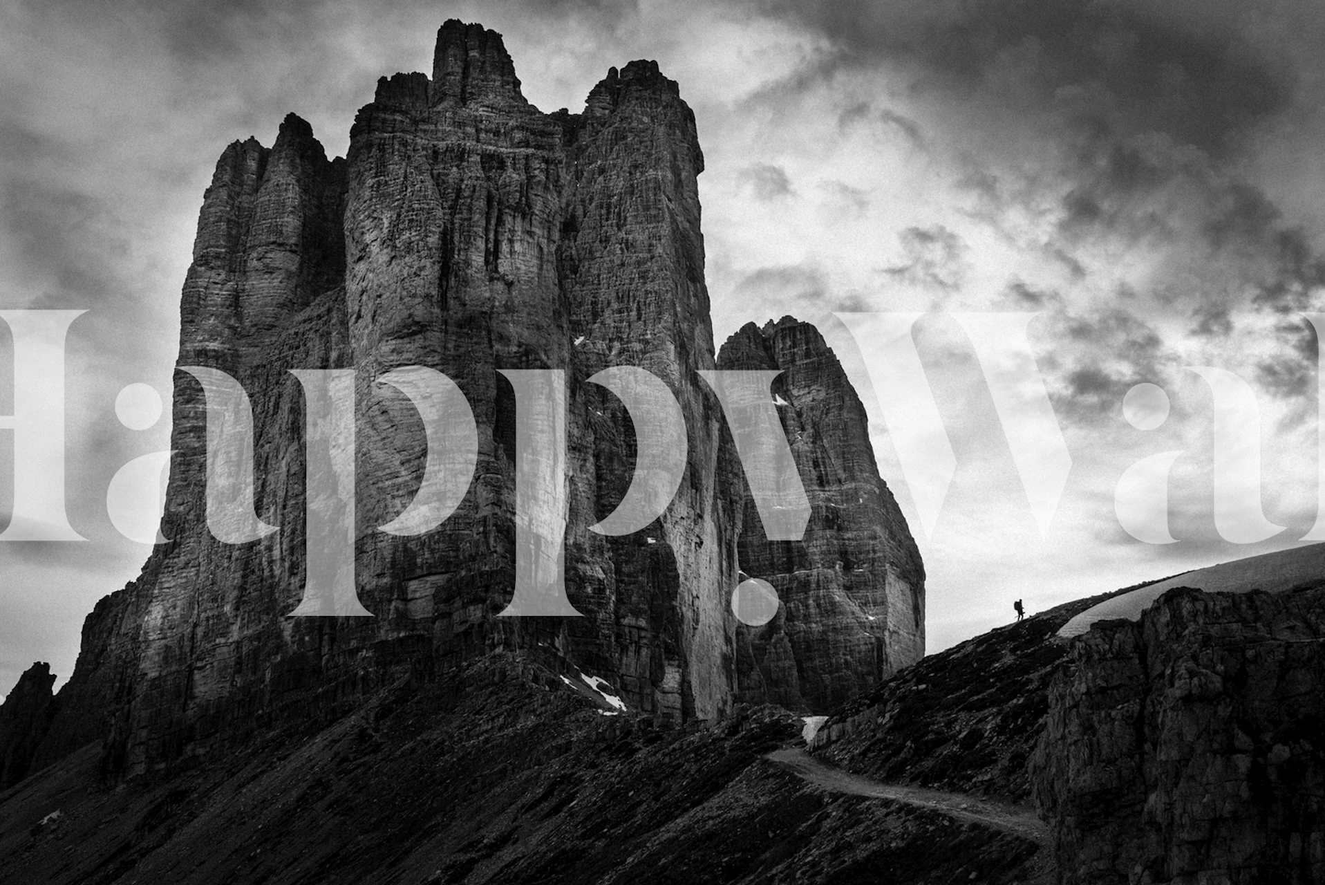 Svart-hvitt veggmaleri av Tre Cime di Lavaredo med en dramatisk himmel og snøhøydepunkter