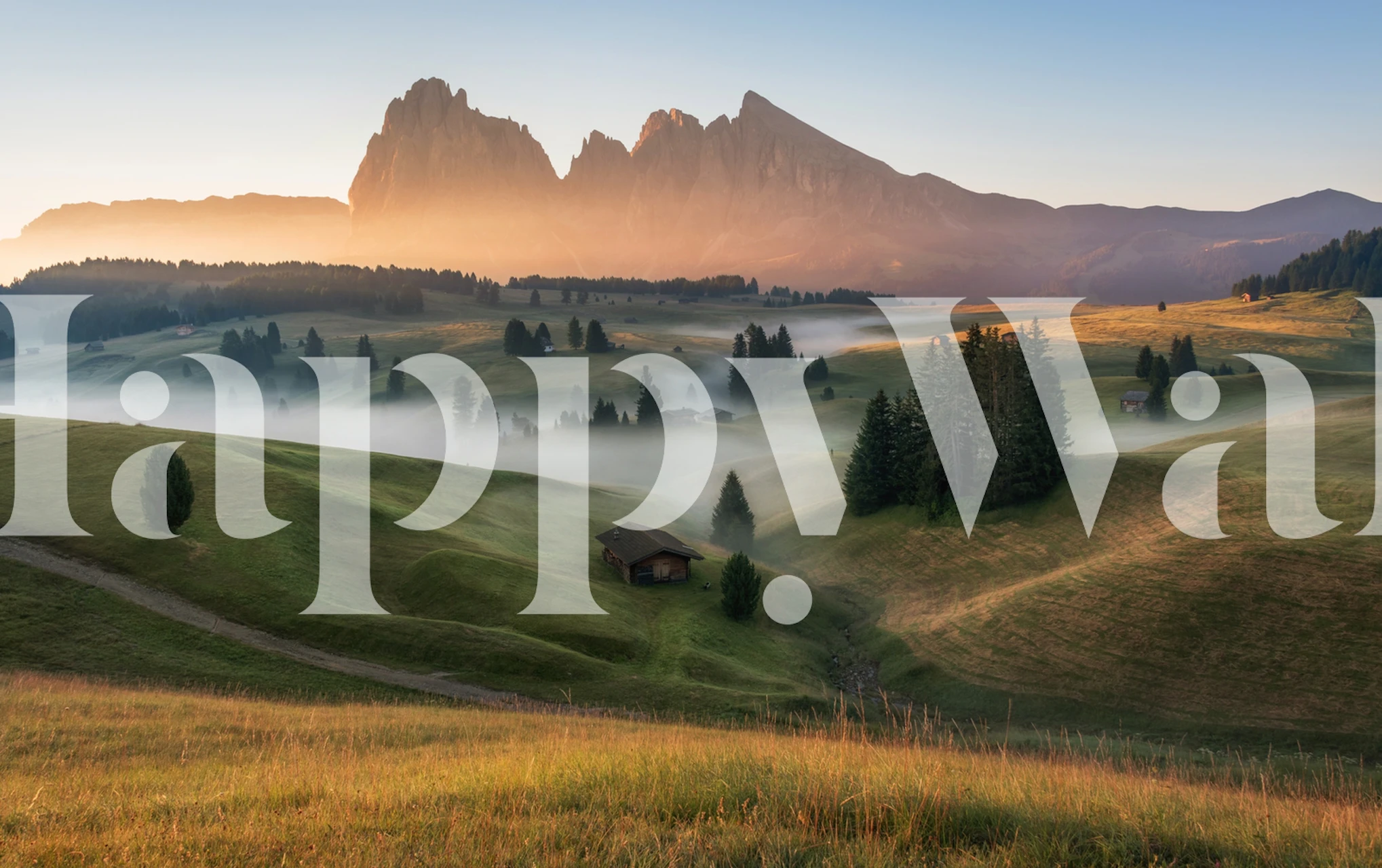 Mountain landscape with green hills, mist, and peaks wallpaper