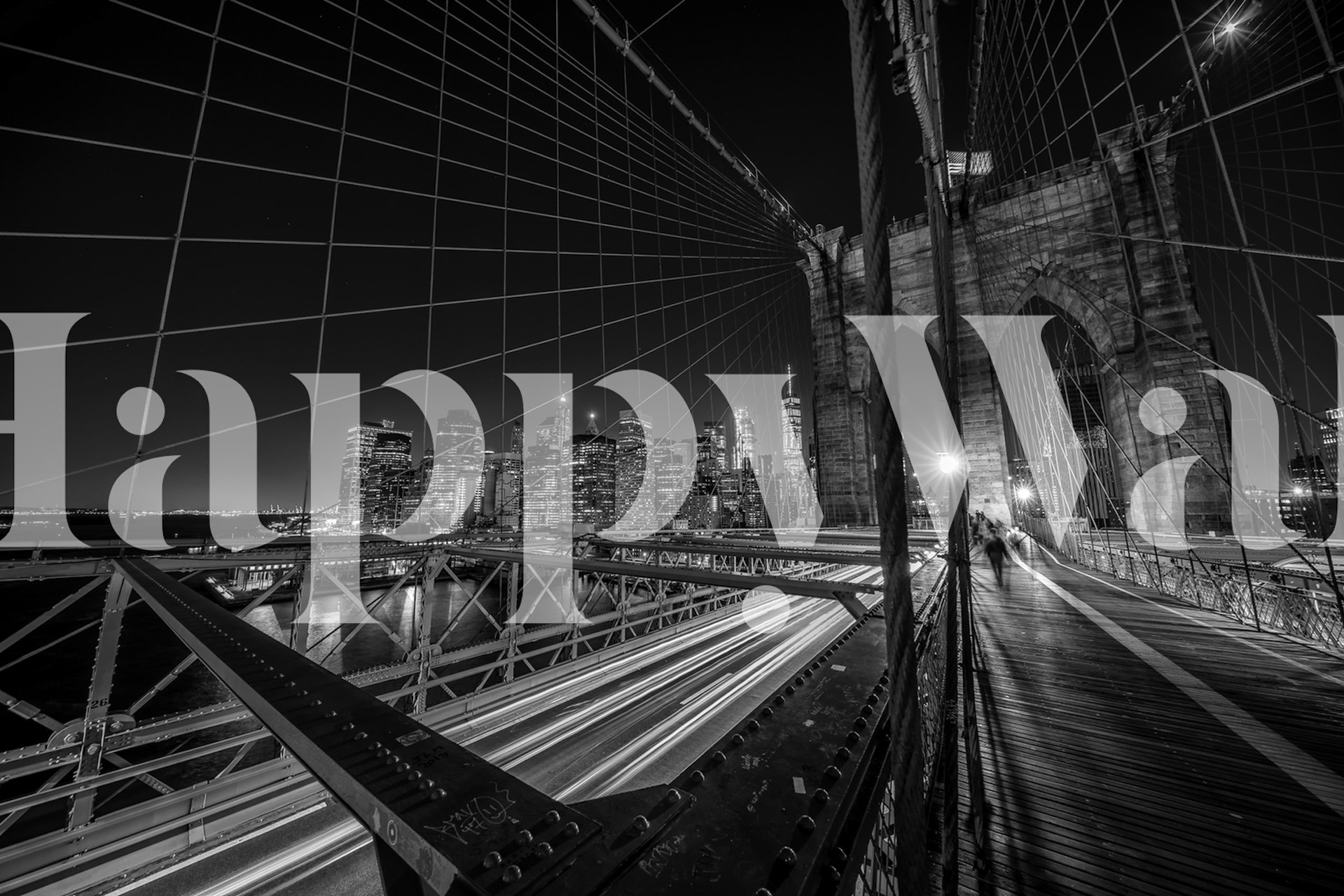 Black and white wall mural of the Brooklyn Bridge at night with city lights