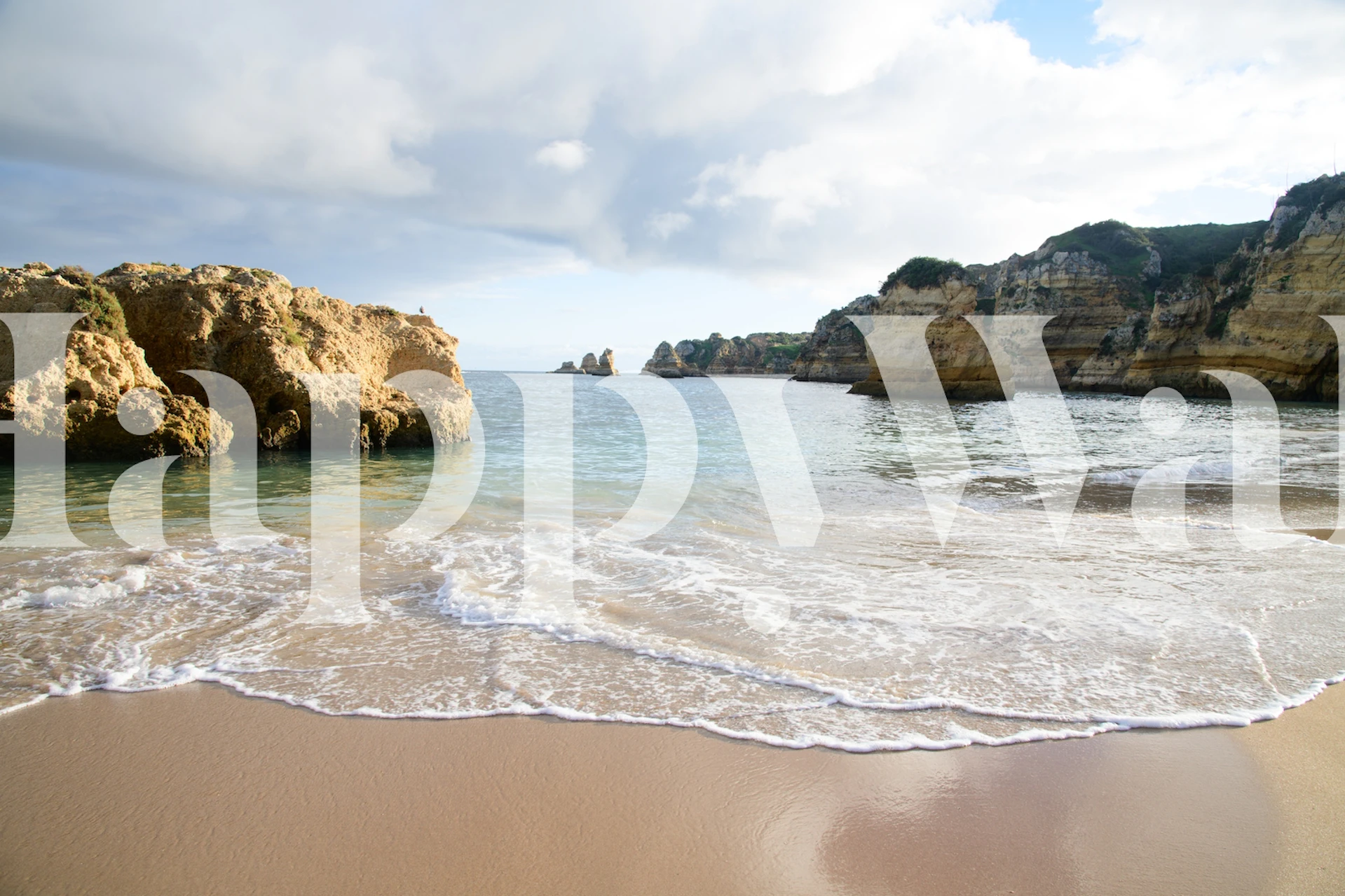 Beach landscape wallpaper featuring sand, water, and cliffs