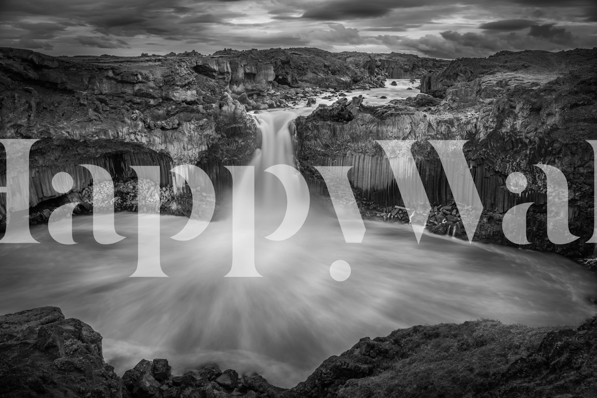 Black and white Icelandic waterfall wall mural displaying dramatic contrasts and nature's grandeur.