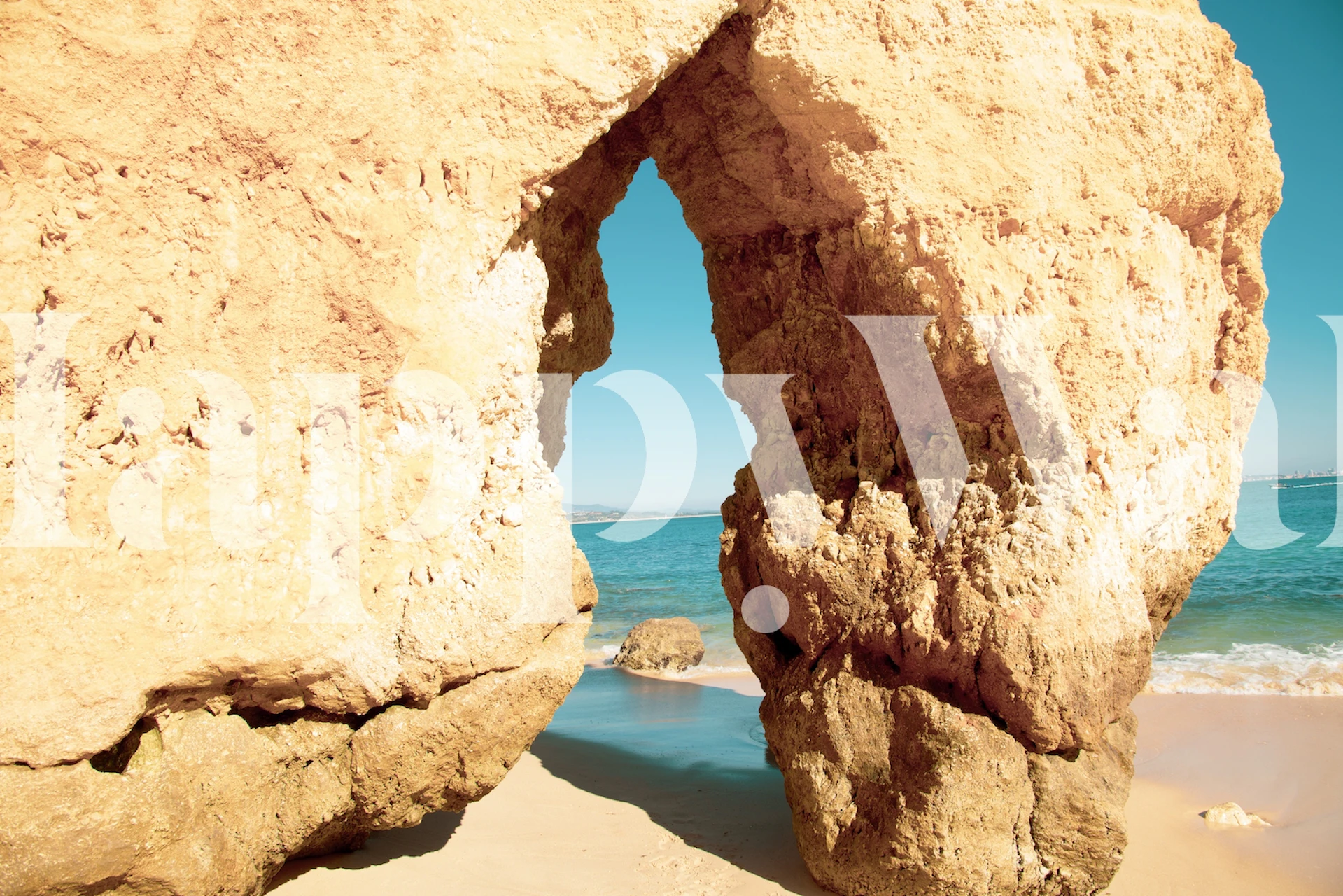 Natural rock archway at Camilo Beach wall mural with blue sky and golden sands