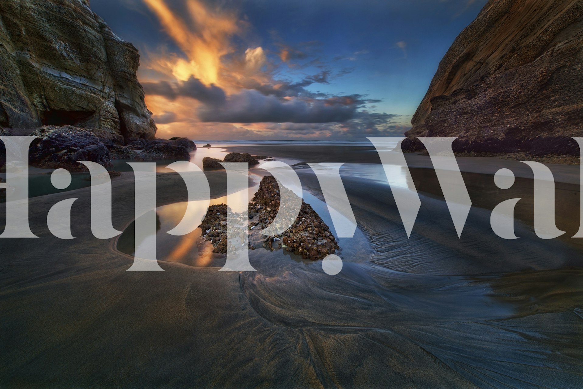 Coastal landscape with blue sky, golden clouds, and rocky beach wallpaper