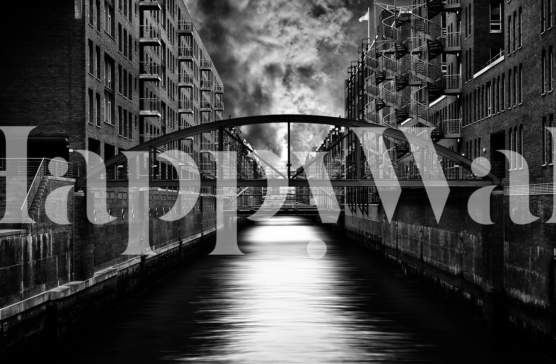 Black and white urban canal scene wallpaper with buildings and bridge.