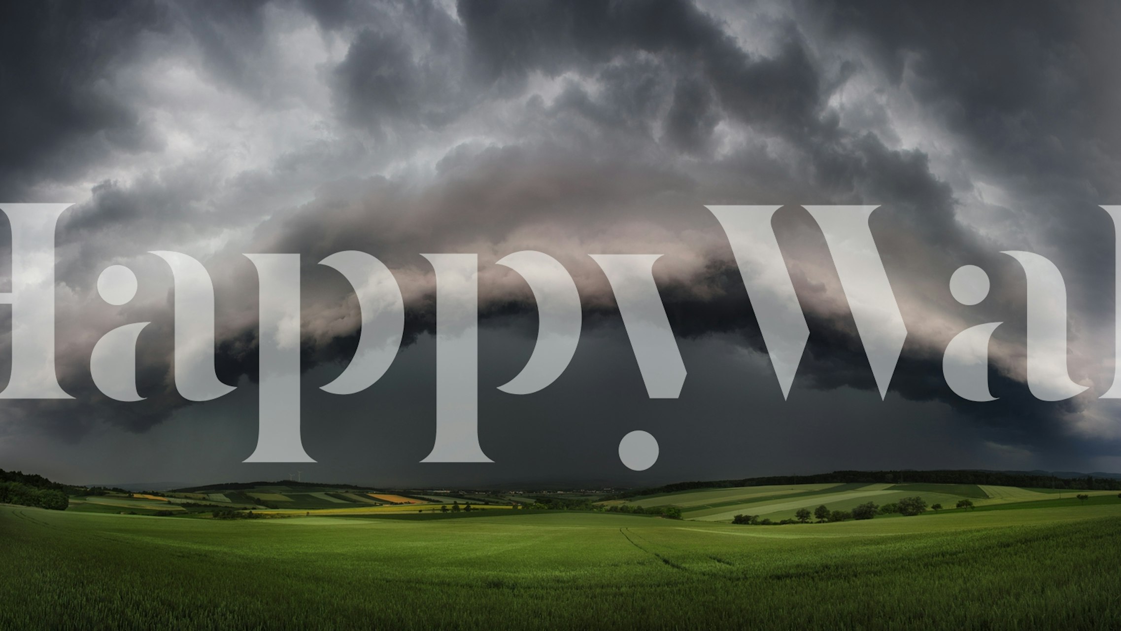 stormy sky with dark gray clouds over green fields wallpaper