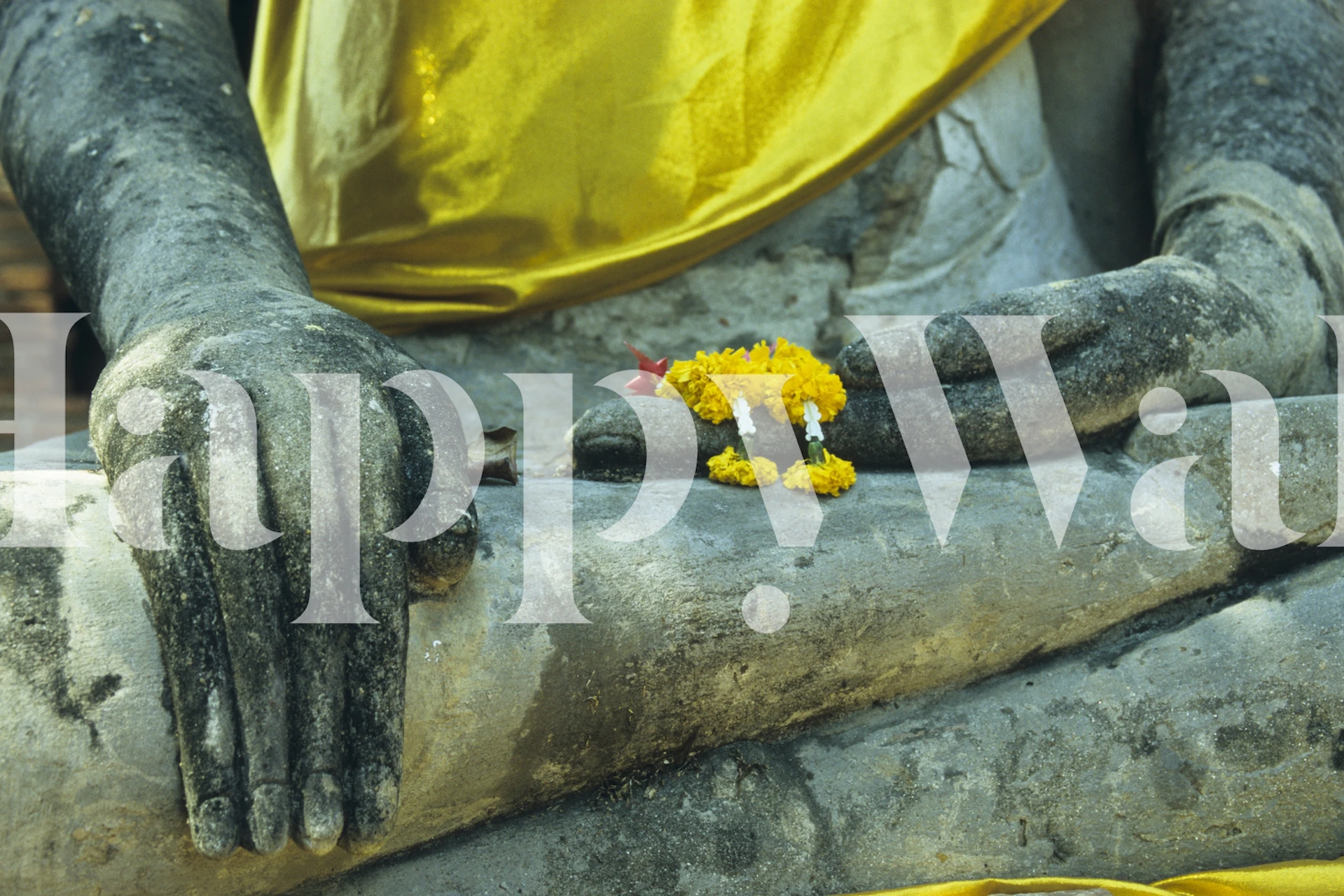 Buddha Statue mit grauer Oberfläche und gelb-goldenem Stofftapete