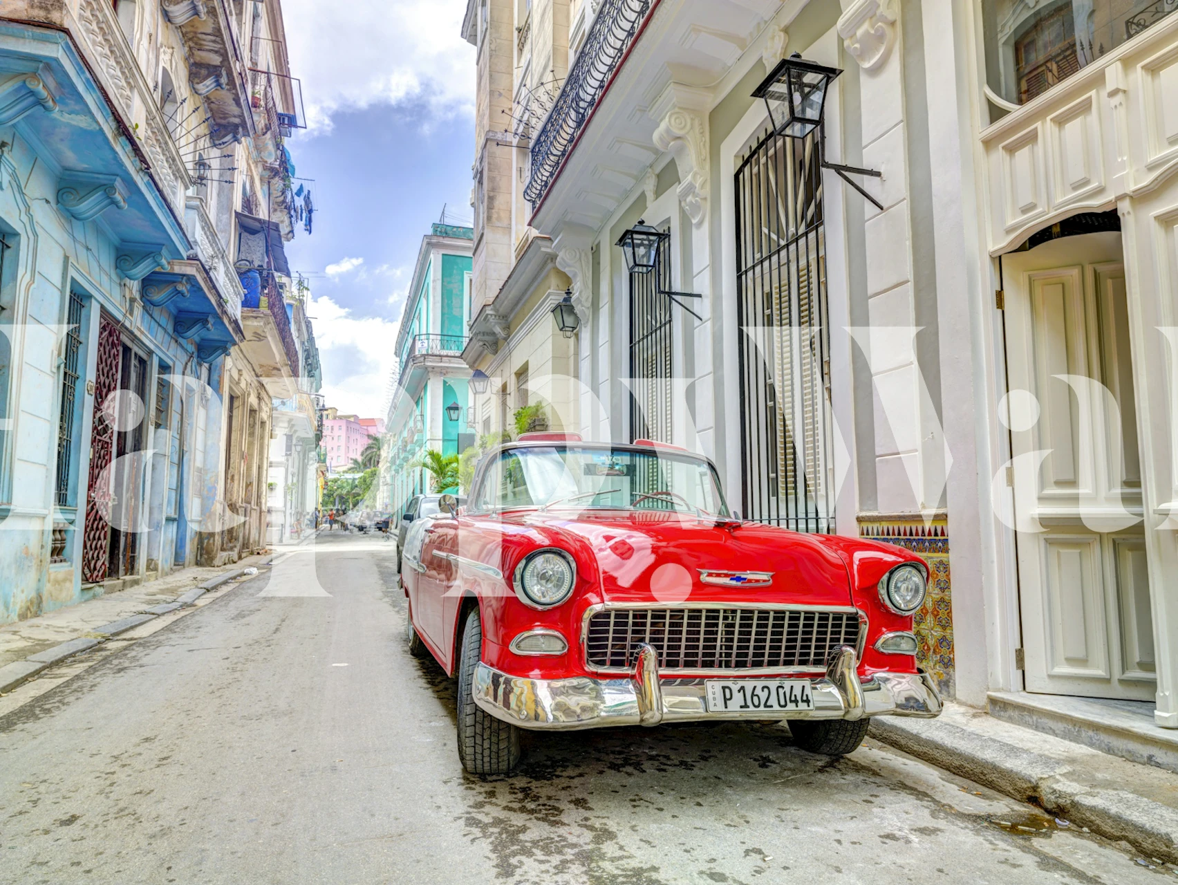 Red vintage car on a narrow Cuban street with colorful buildings wallpaper