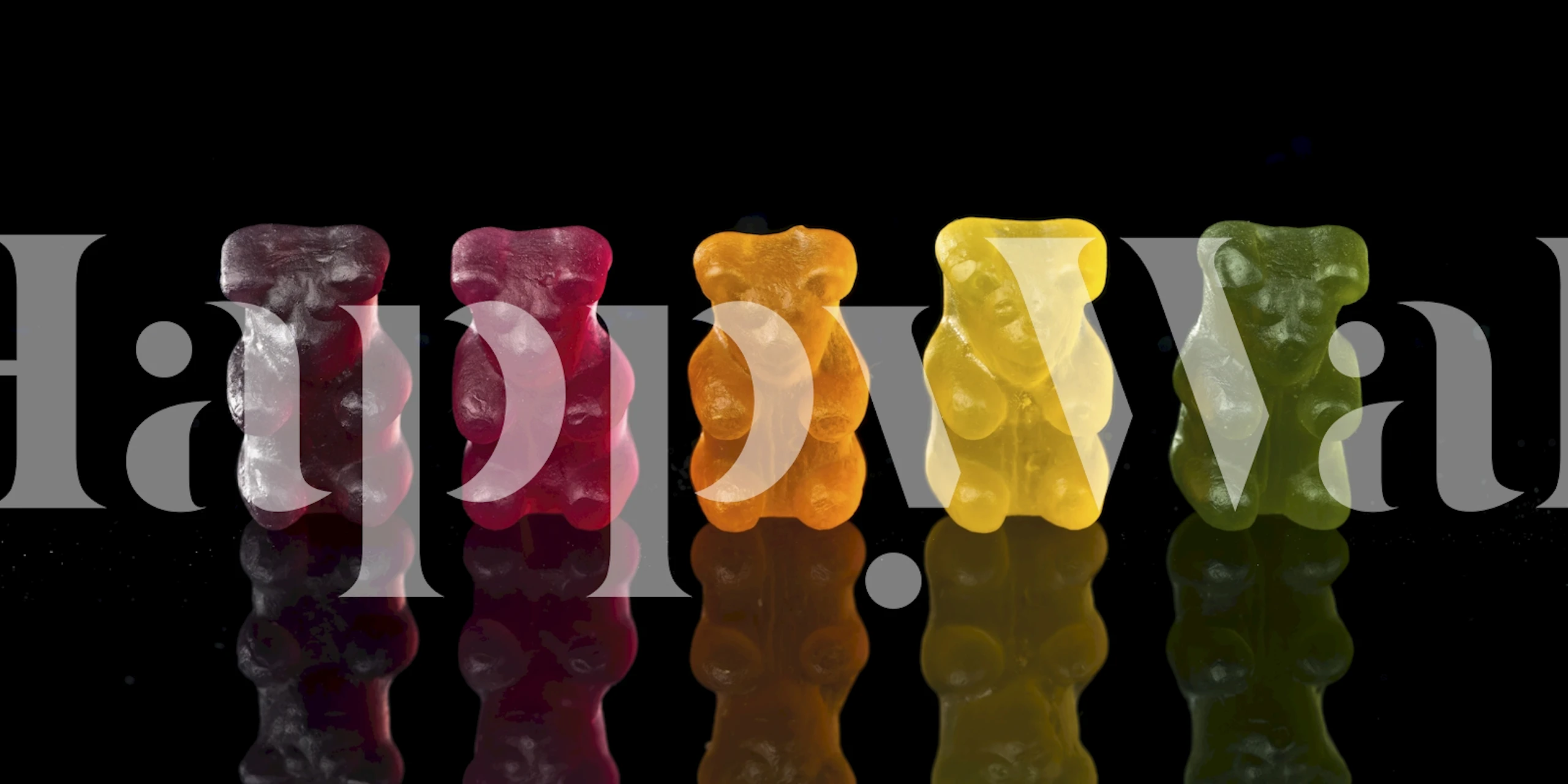 Colorful jelly bears in red, pink, orange, yellow, and green on a black background wallpaper