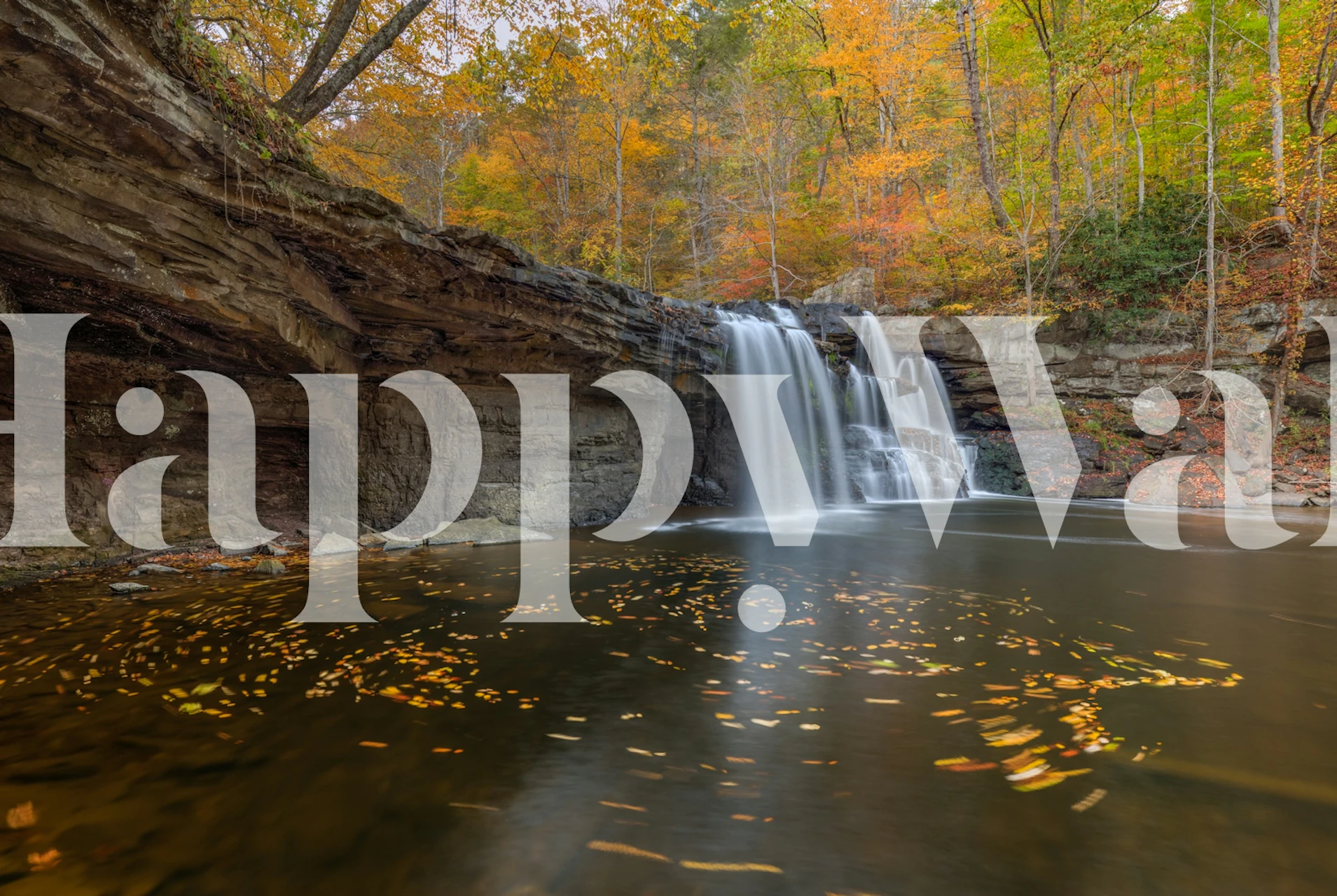 Autumn waterfall scene with colorful foliage and flowing water wallpaper