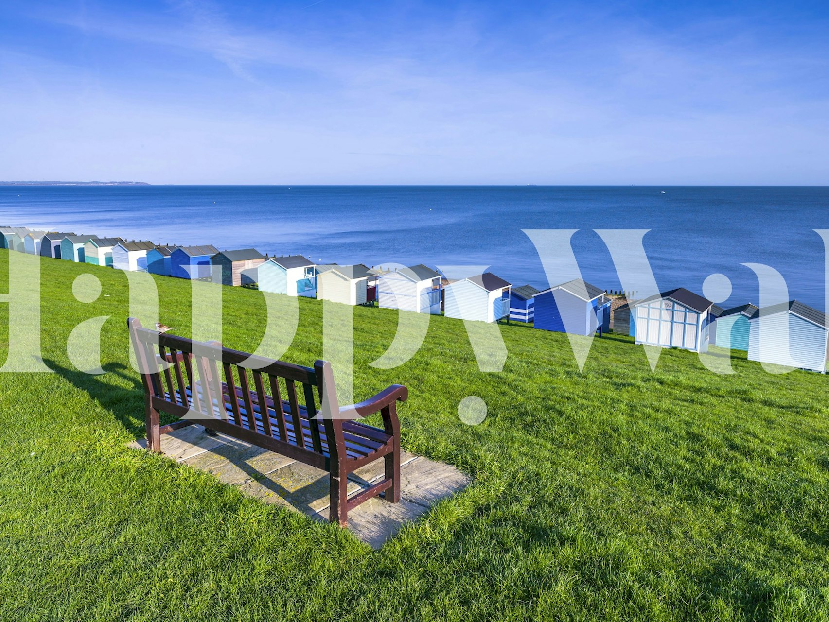 Coastal scene with colorful beach huts and blue ocean wallpaper