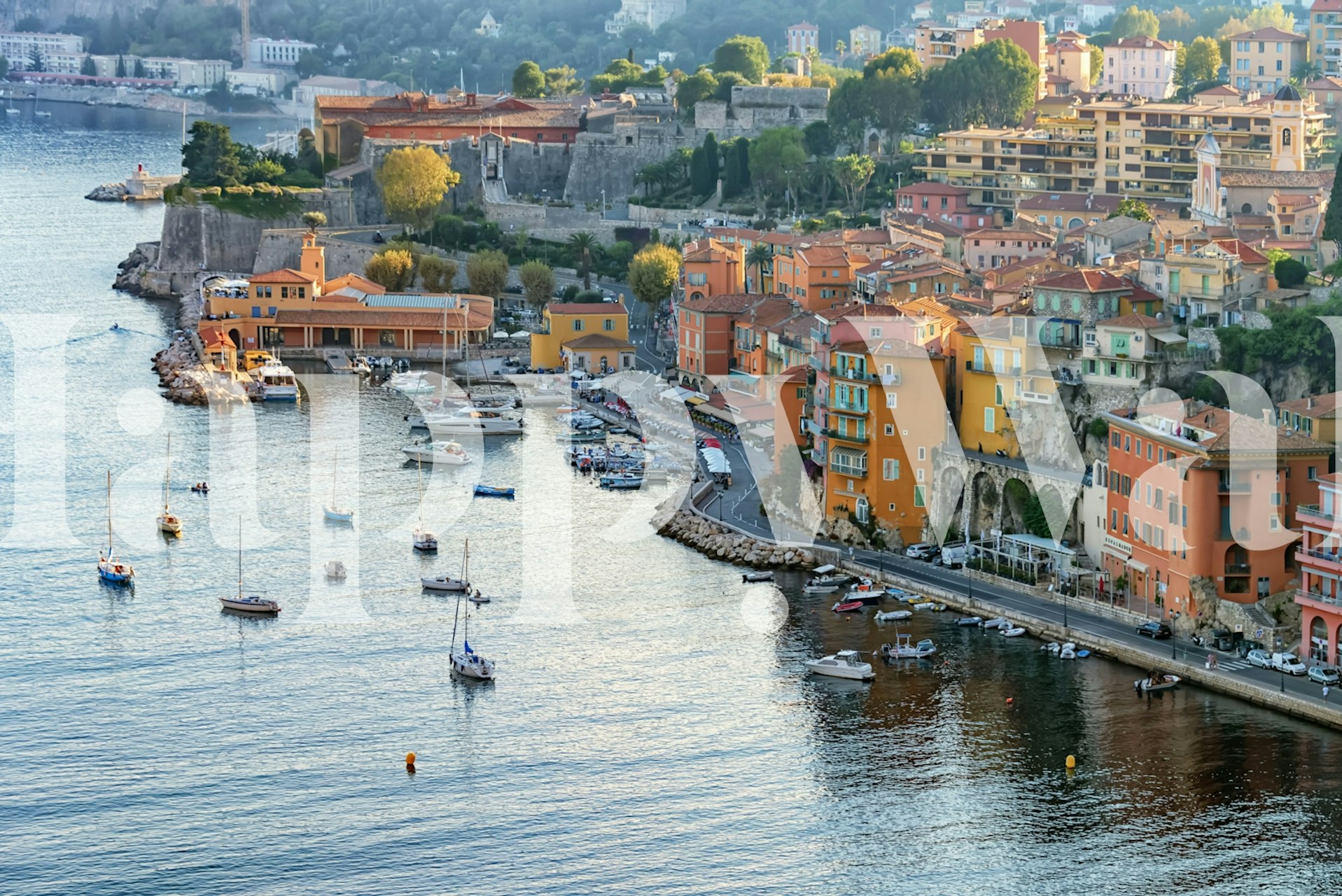 Colorful waterfront village scene with boats and hills wallpaper