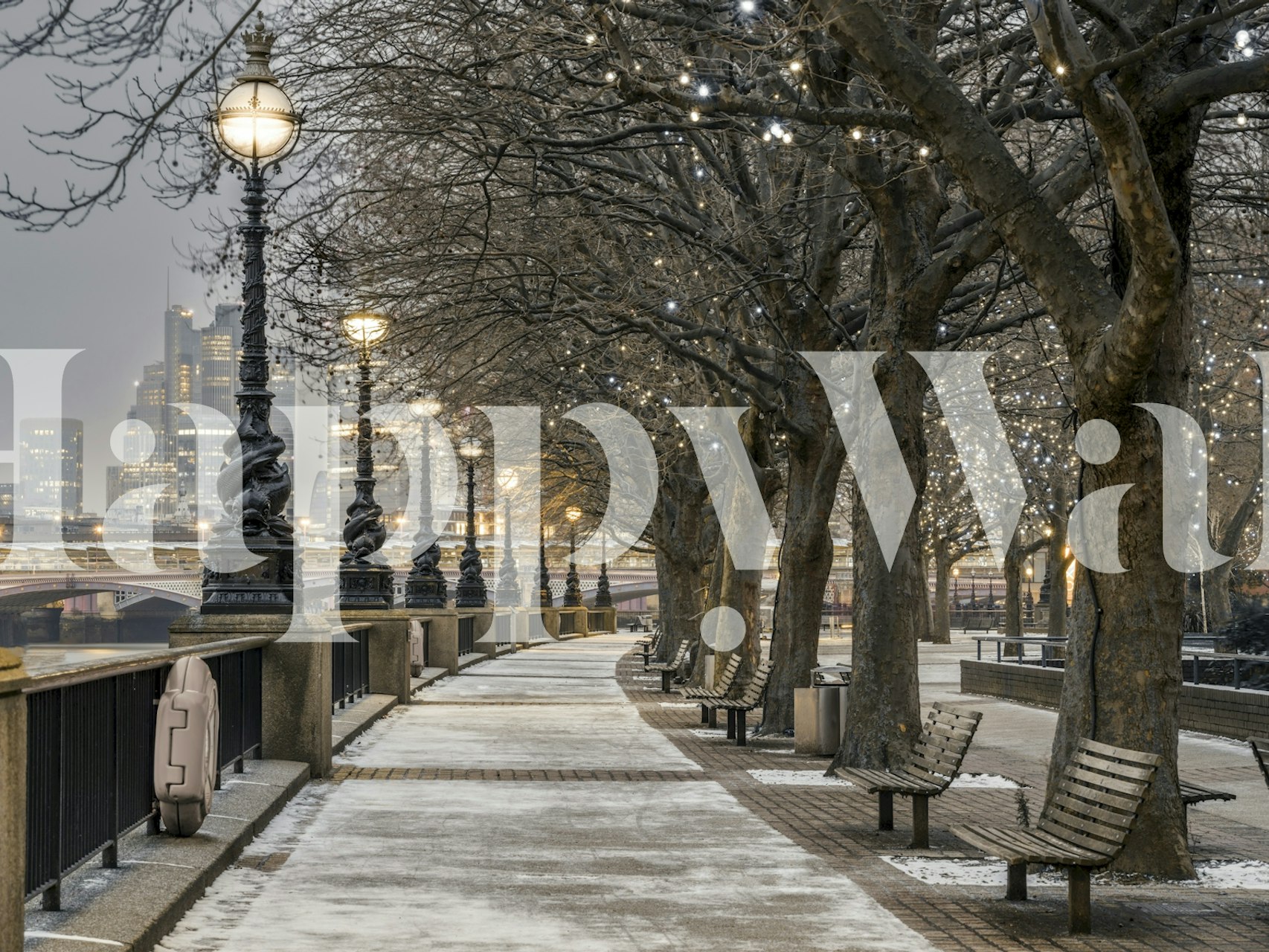 Snowy street view with lamp posts and city lights wallpaper