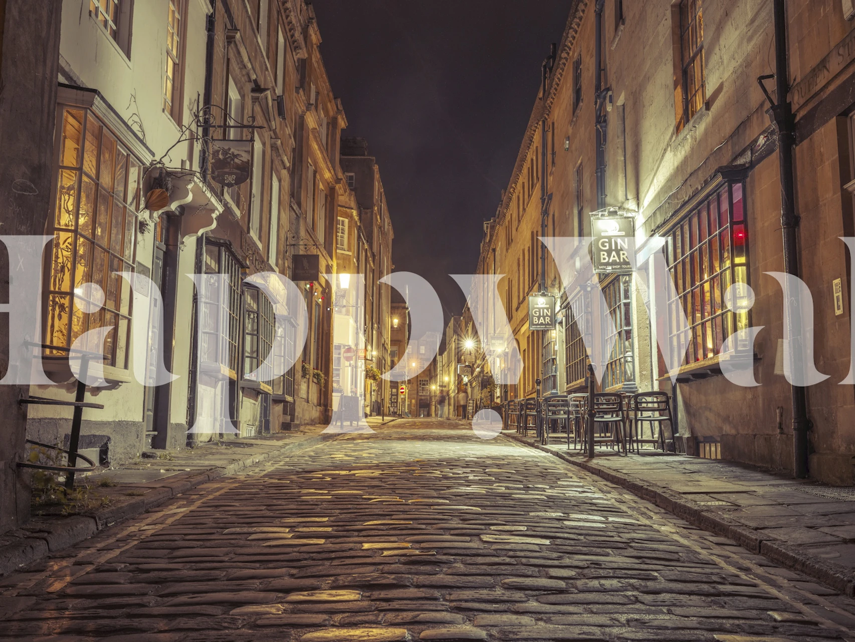 Cobblestone street at night with warm lights wallpaper